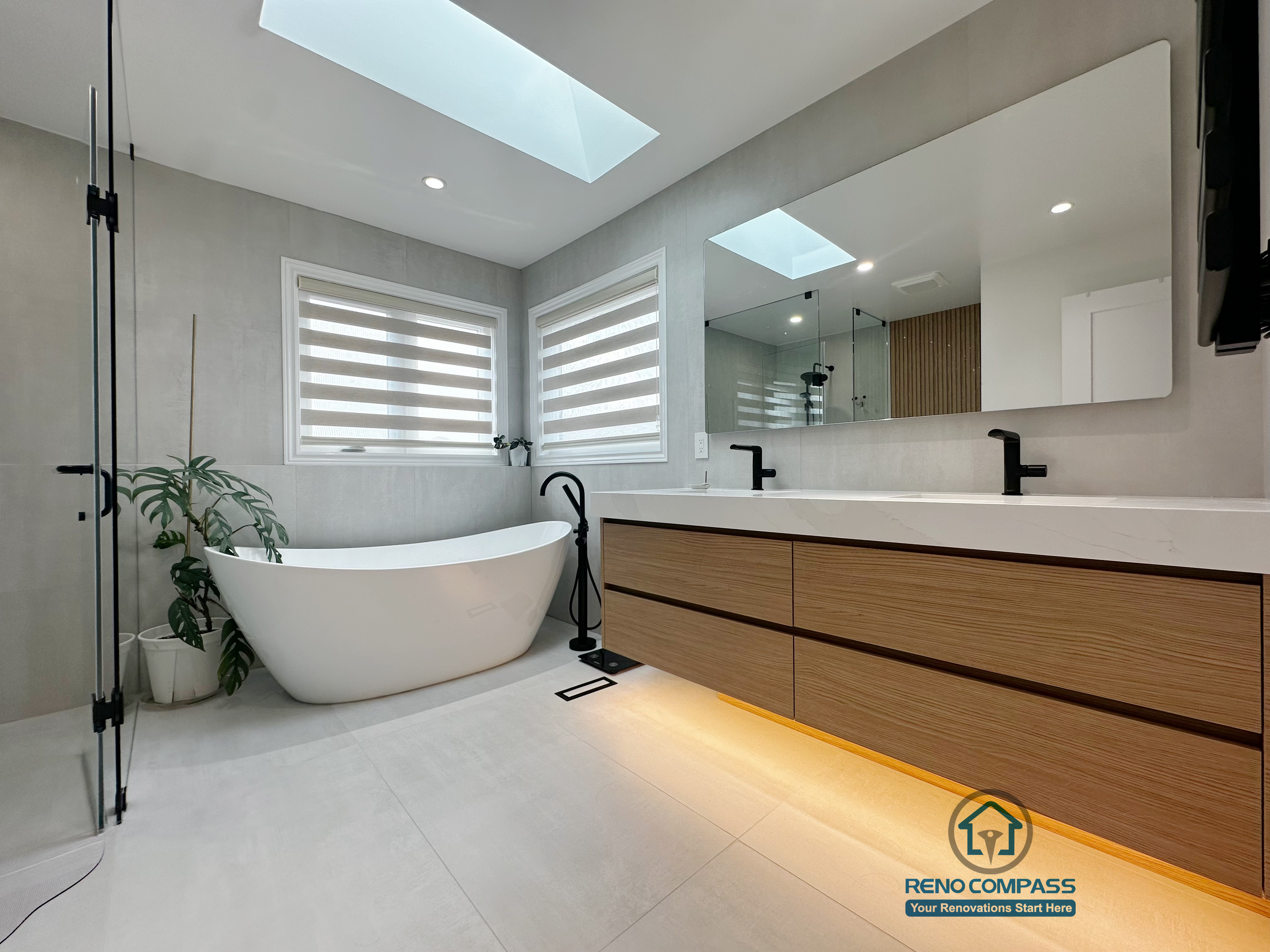 A modern curbless bathroom renovation completed by Reno Compass in Markham, Toronto.
This space features a freestanding bathtub, floating double-sink vanity with warm under-cabinet lighting, and abundant natural light, creating a calm, spa-inspired atmosphere designed for everyday comfort.