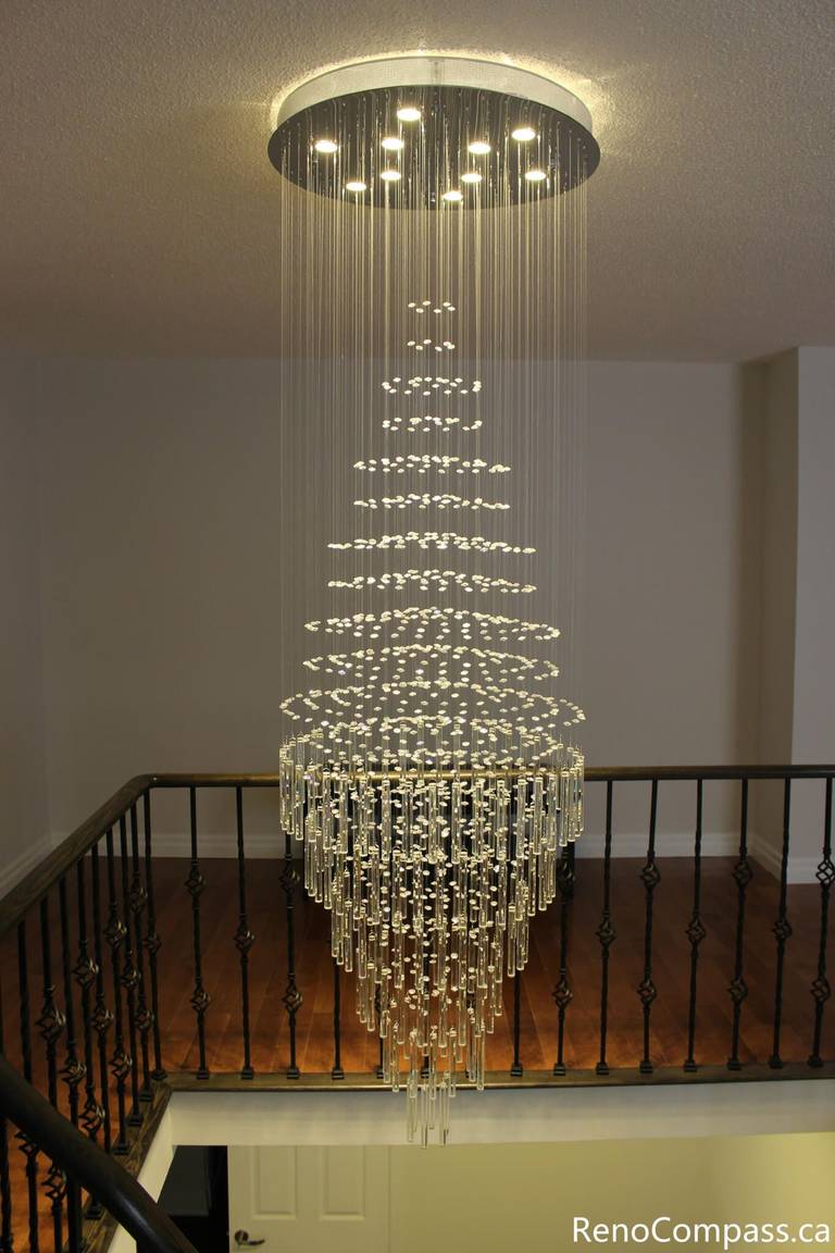 This Mississauga interior renovation features a stunning modern crystal chandelier installation above the staircase, creating a luxurious focal point and enhancing the home's lighting design. The elegant fixture adds depth, brightness, and contemporary sophistication to the open space. Completed by a professional Toronto renovation company, Reno Compass Inc., this project highlights premium interior upgrades and detailed finishing craftsmanship.