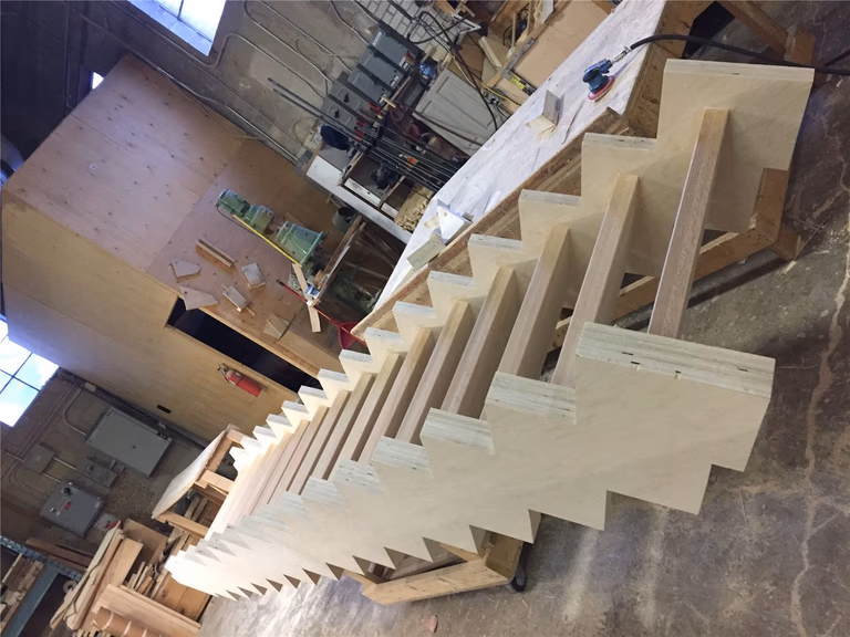 This image shows a custom hardwood staircase frame being built for a Toronto stair renovation project. The staircase structure is carefully fabricated with precise step spacing and strong side support to ensure stability, durability, and a clean final finish. This stage highlights the detailed carpentry work behind a high-quality custom stair build. As a reliable Toronto Renovation Company, Reno Compass Inc. provides expert staircase renovation and custom wood construction services for homes across Toronto and the GTA.