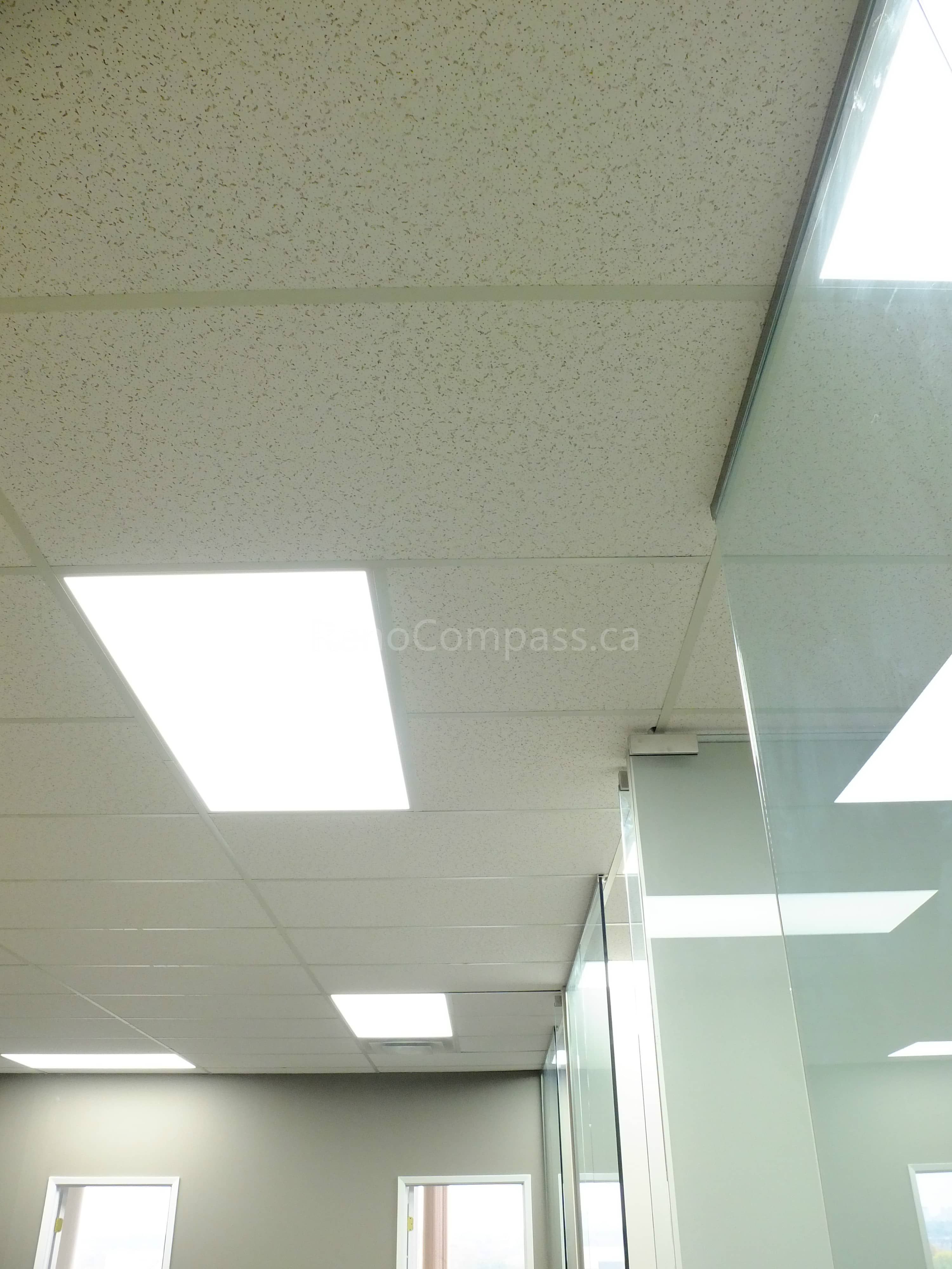 This photo shows a newly renovated office ceiling in North York, featuring modern suspended ceiling tiles and bright energy-efficient LED panel lights. The clean design enhances workspace illumination and creates a professional office environment.