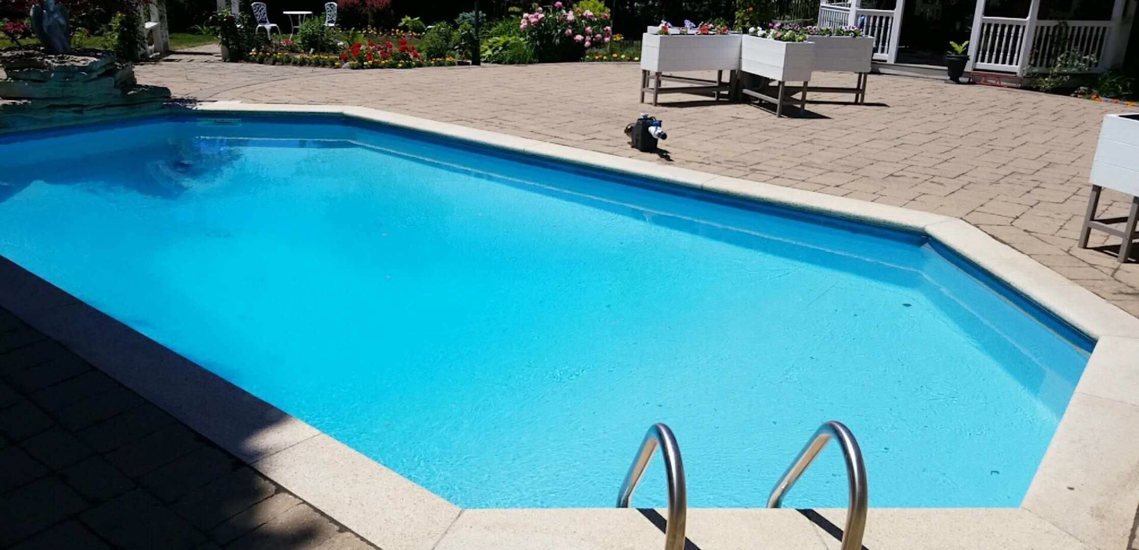 After renovation photo of a fully restored backyard swimming pool in Toronto. The new bright blue liner, clean water, and resurfaced edges highlight the professional pool transformation from old and damaged to modern and inviting. Expert pool renovation by local Toronto specialists.