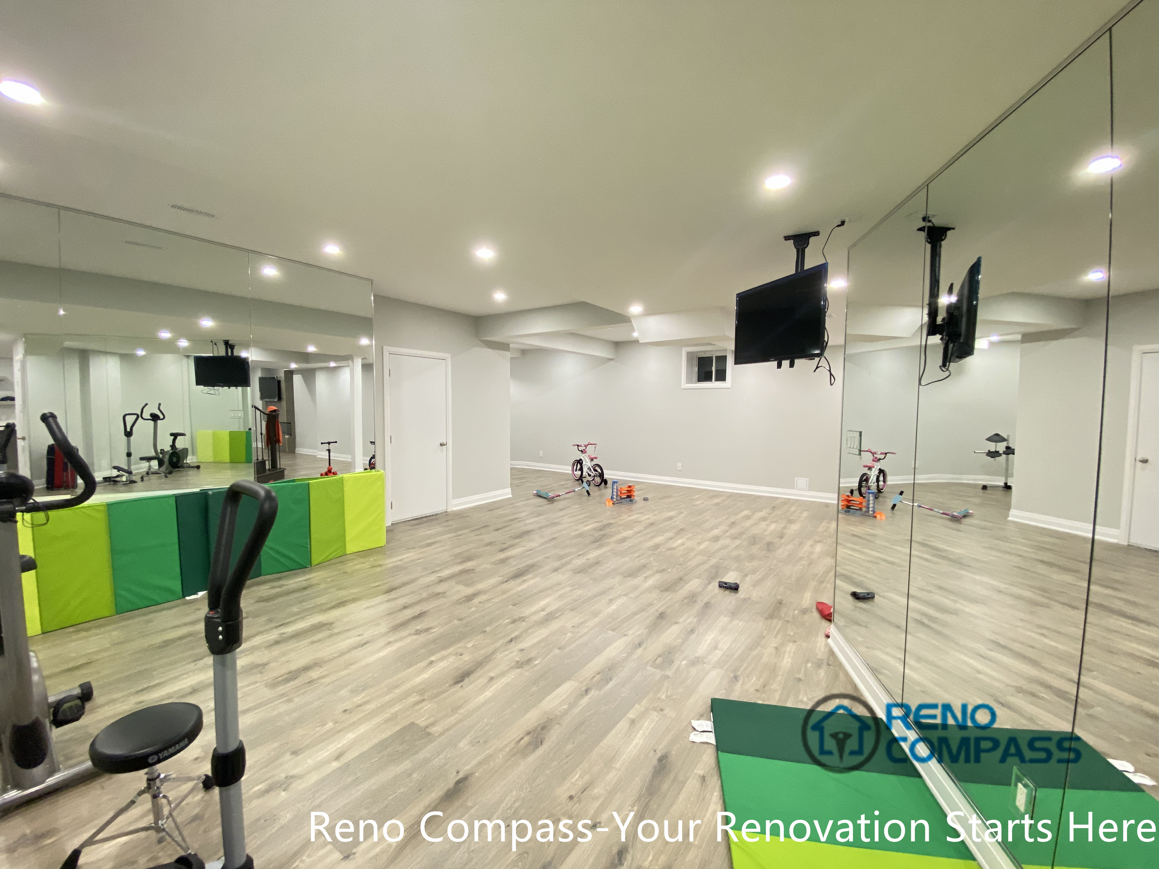 This Newmarket basement renovation features a dedicated home gym area with full-height mirrored walls, recessed ceiling lighting, and durable wood-look flooring. Designed and built by a professional Toronto renovation company, the space supports fitness training, stretching, and multi-purpose activities while enhancing brightness and visual openness—ideal for an active lifestyle within a finished basement environment.