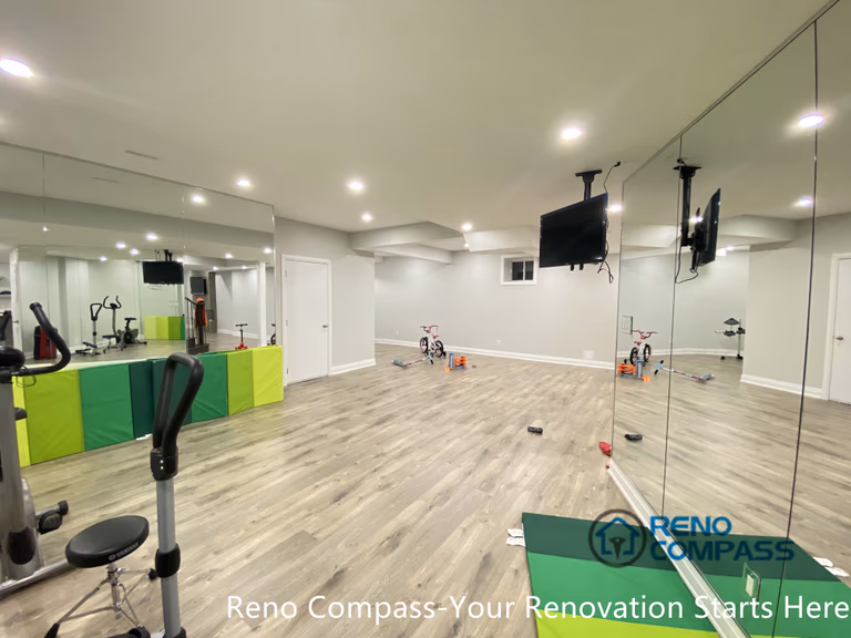 This Newmarket basement renovation features a dedicated home gym area with full-height mirrored walls, recessed ceiling lighting, and durable wood-look flooring. Designed and built by a professional Toronto renovation company, the space supports fitness training, stretching, and multi-purpose activities while enhancing brightness and visual openness—ideal for an active lifestyle within a finished basement environment.