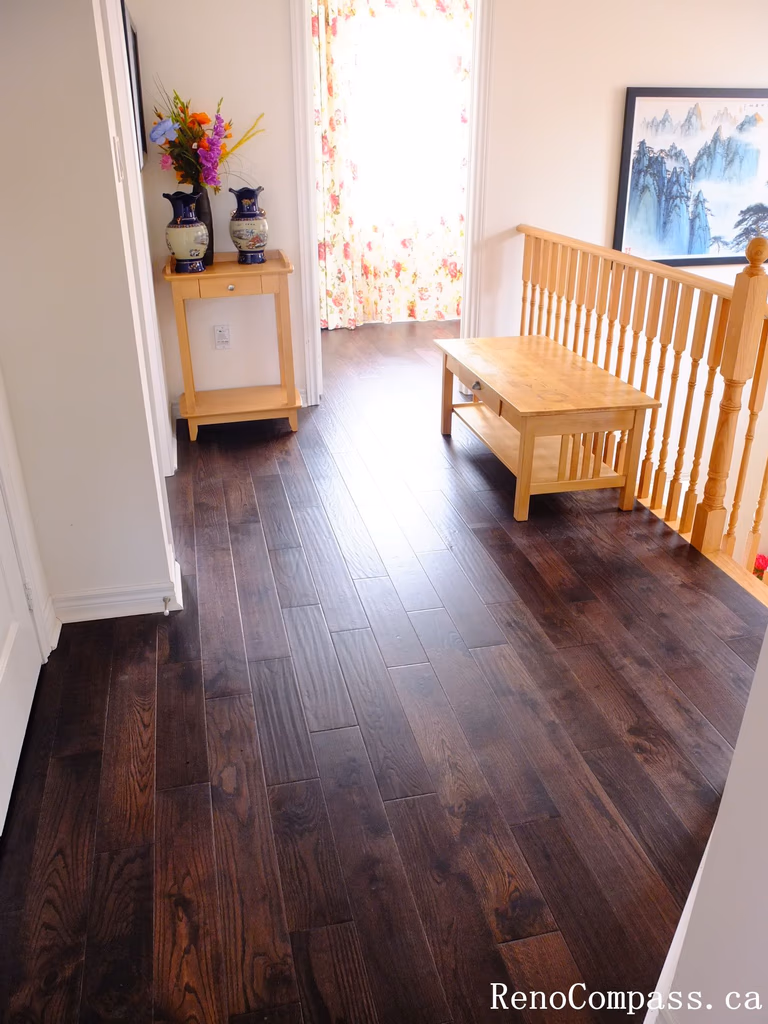 Toronto home hardwood flooring installation featuring deep-toned wood floors throughout the hallway and upper level. This professional flooring renovation enhances brightness, durability, and visual continuity, completed by Reno Compass for a clean and modern interior upgrade.