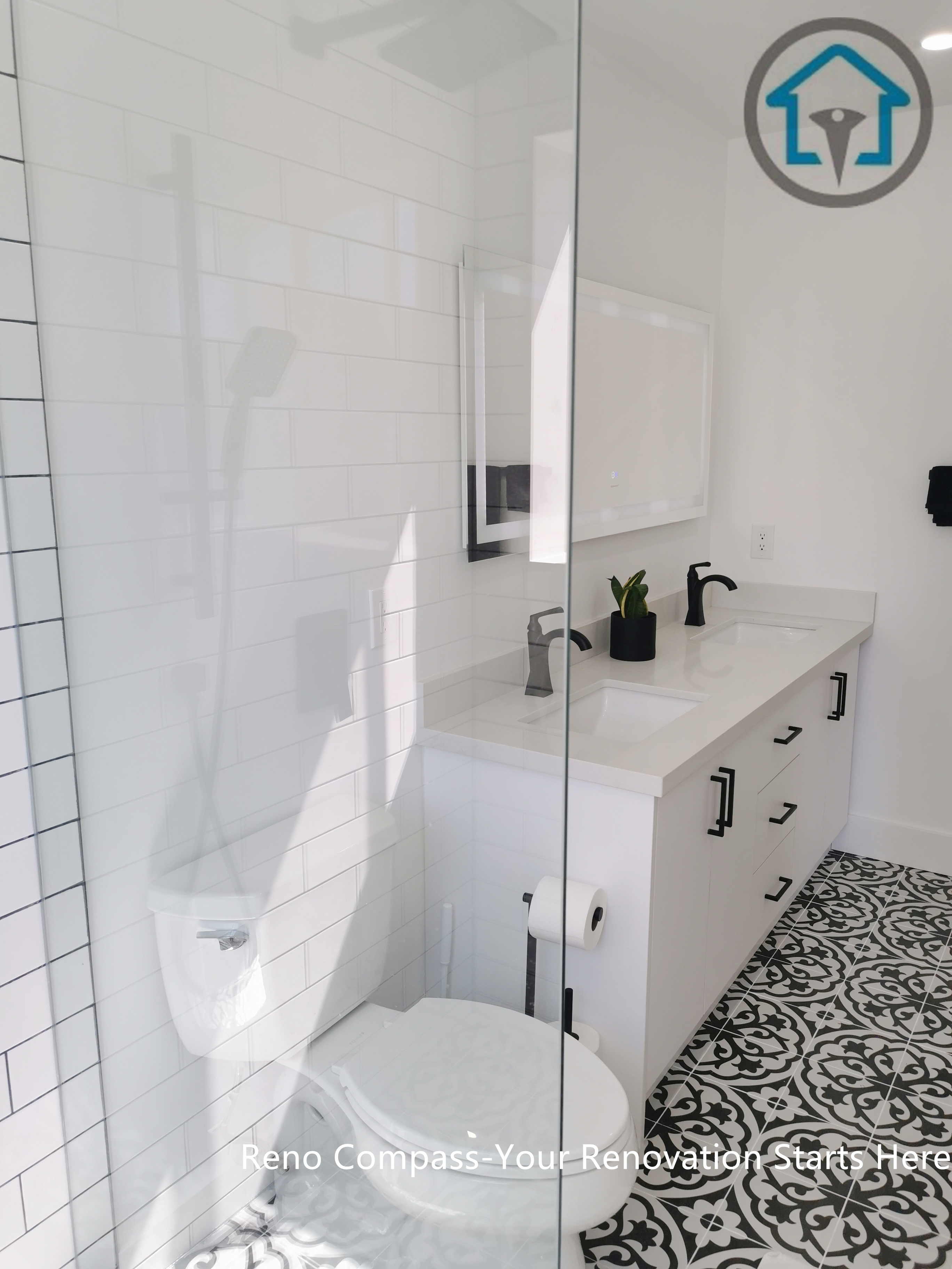 This Ajax bathroom renovation features a clean and timeless design with a white double-sink vanity, matte black fixtures, and a glass-enclosed shower. The patterned tile floor adds visual character while keeping the overall space bright, functional, and easy to maintain—perfect for modern family living.