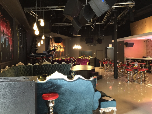 This image showcases the completed lounge area of a 7000 sqft private club renovation project in Toronto. The space features custom velvet sofas with gold trim details, elevated stage setup, professional lighting truss system, and a spacious entertainment layout designed for private events and nightlife experiences.

The open-concept floor plan integrates lounge seating, bar-height tables, and performance areas, creating a refined yet dynamic atmosphere. High ceilings, industrial-style lighting, and polished flooring enhance the sense of scale and sophistication.

Completed by a professional Toronto renovation team, this project demonstrates expertise in large-scale commercial interior construction, combining luxury aesthetics with functional entertainment space planning.