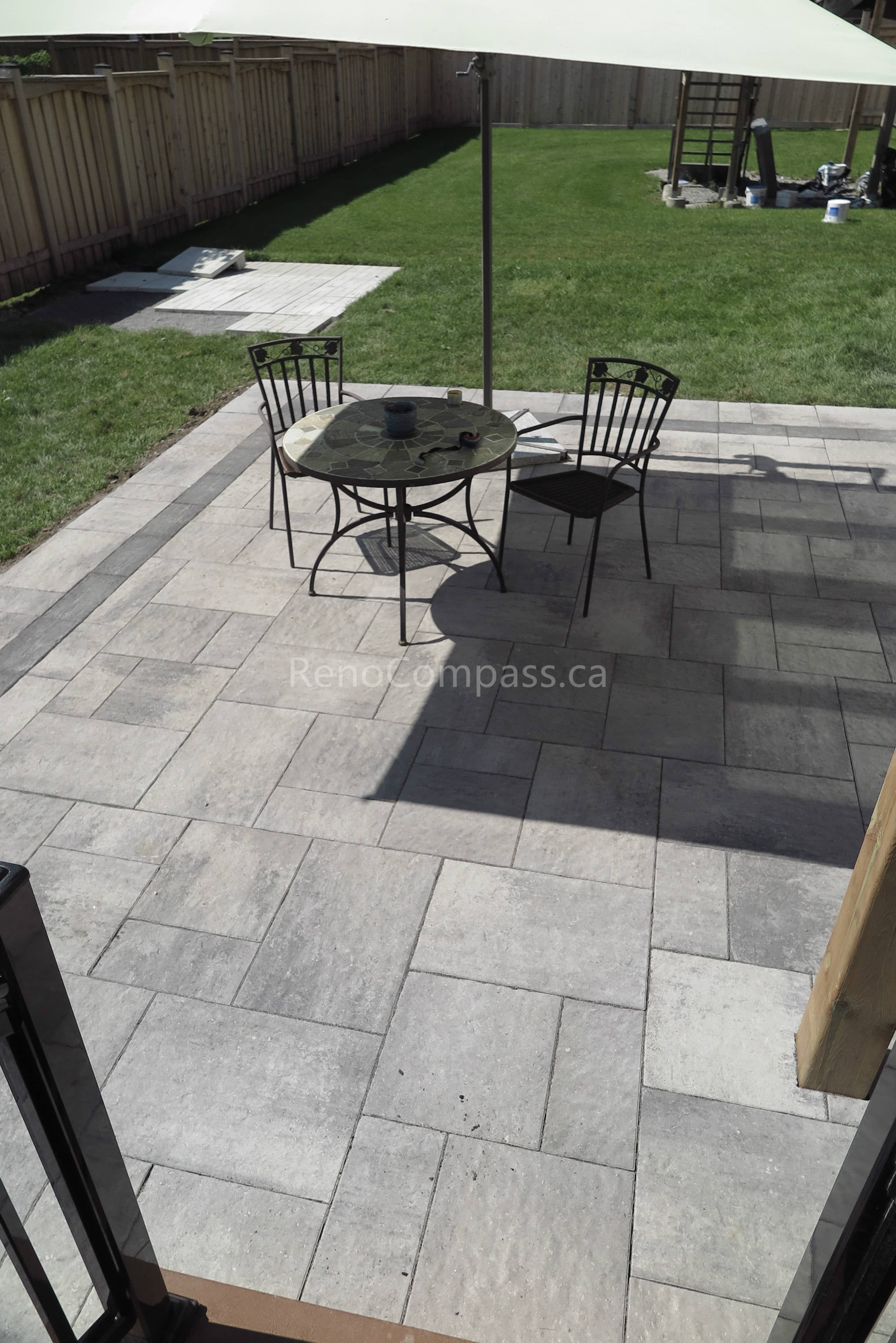This Markham backyard landscaping project highlights a professionally installed interlock stone patio with a modern rectangular pattern and contrasting border design. The clean layout provides a spacious outdoor seating area ideal for dining and relaxation. Built for durability and low maintenance, the patio enhances both functionality and visual appeal while seamlessly connecting the home to the backyard lawn. Completed by Reno Compass, this project delivers a refined and practical outdoor living space for everyday enjoyment and summer gatherings.