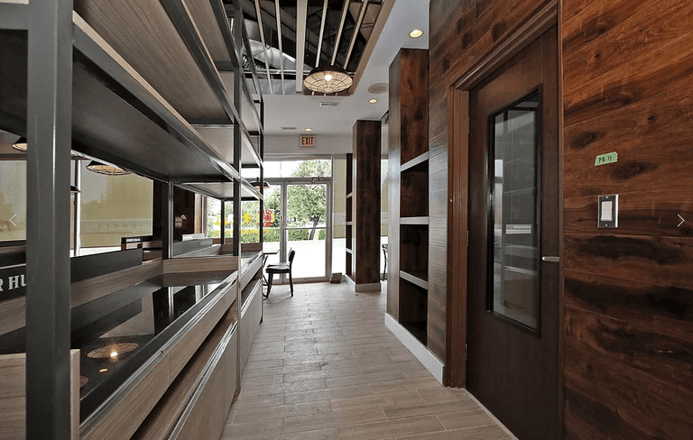 Professional restaurant interior renovation in Markham featuring custom wood wall finishes, commercial kitchen service area, modern ceiling design, and durable flooring. Designed to improve workflow efficiency and customer experience for restaurant operations. Completed by a trusted Toronto renovation company, Reno Compass Inc., specializing in restaurant and commercial renovation projects across the GTA.