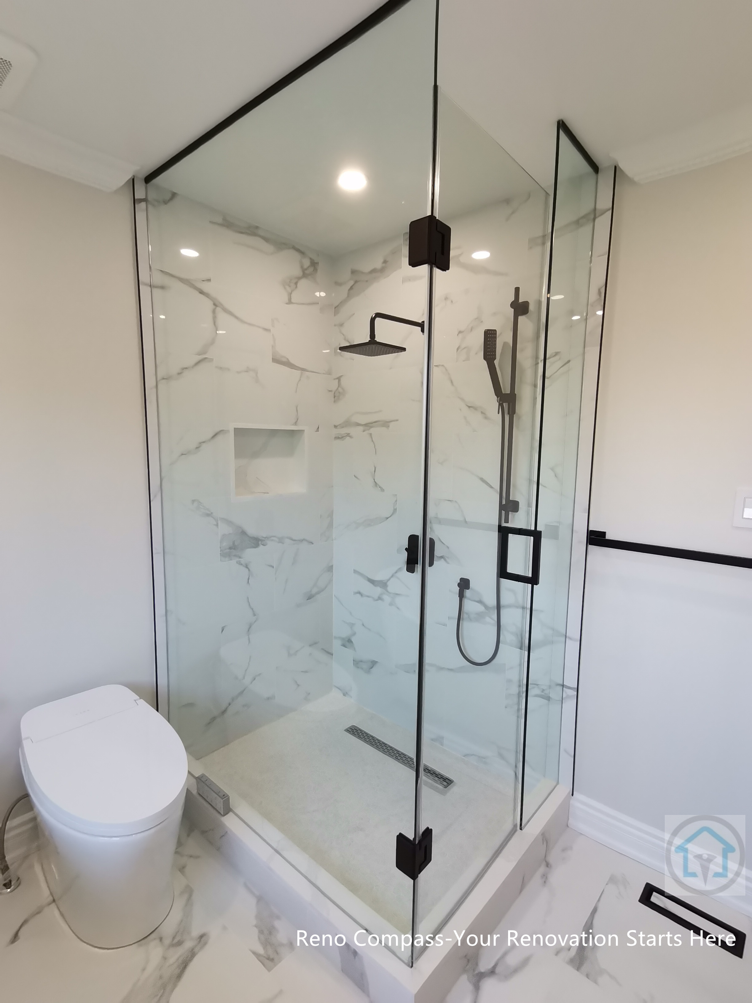 This Thornhill bathroom renovation features a glass-enclosed shower with marble-style wall tiles, modern black fixtures, and a built-in niche for storage. The clean layout integrates the shower area seamlessly with the rest of the bathroom, creating a bright, functional, and well-balanced space for everyday use.