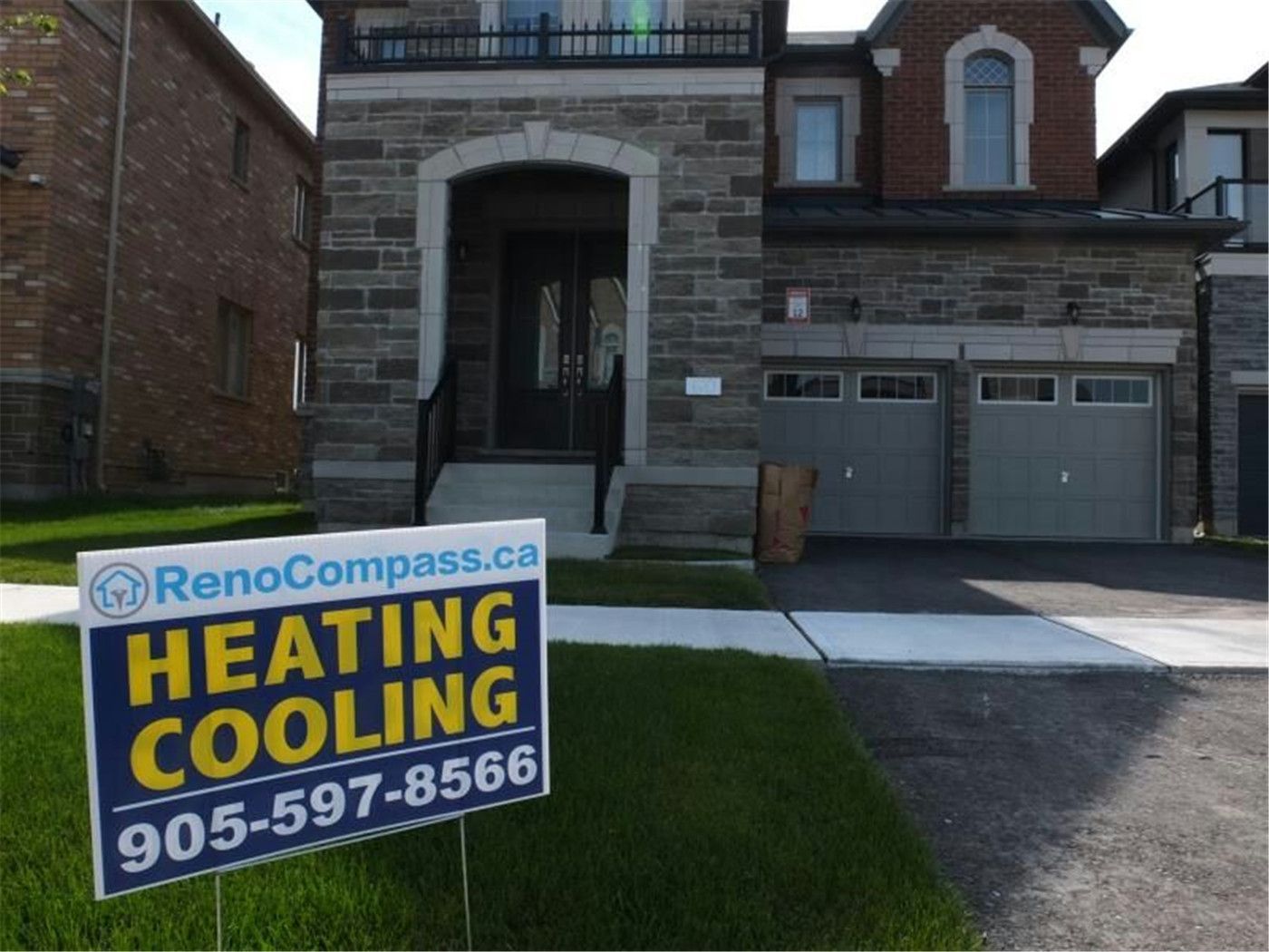 Professional outdoor air conditioner condenser installation by Reno Compass in Toronto. This energy-efficient HVAC unit is securely mounted on a raised stand with proper drainage and ventilation clearance, ensuring optimal cooling performance, durability, and safe operation for residential homes. Installed by licensed technicians for long-term reliability and comfort.