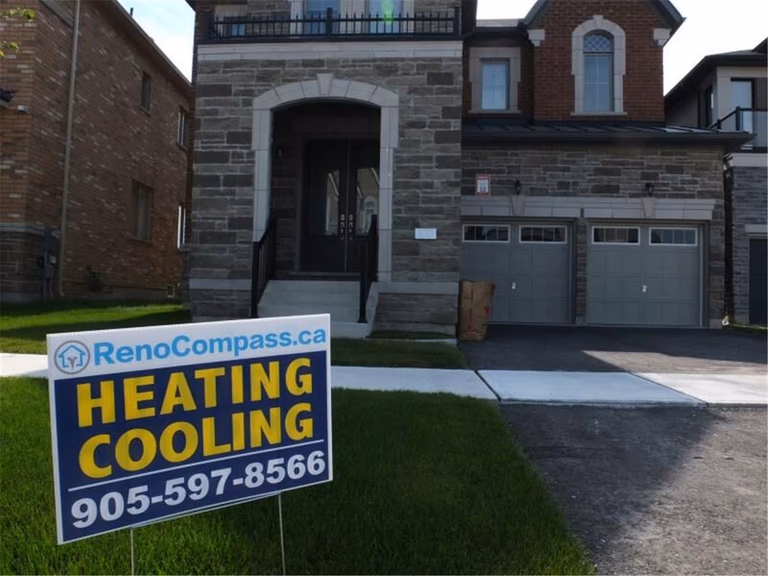 Professional outdoor air conditioner condenser installation by Reno Compass in Toronto. This energy-efficient HVAC unit is securely mounted on a raised stand with proper drainage and ventilation clearance, ensuring optimal cooling performance, durability, and safe operation for residential homes. Installed by licensed technicians for long-term reliability and comfort.