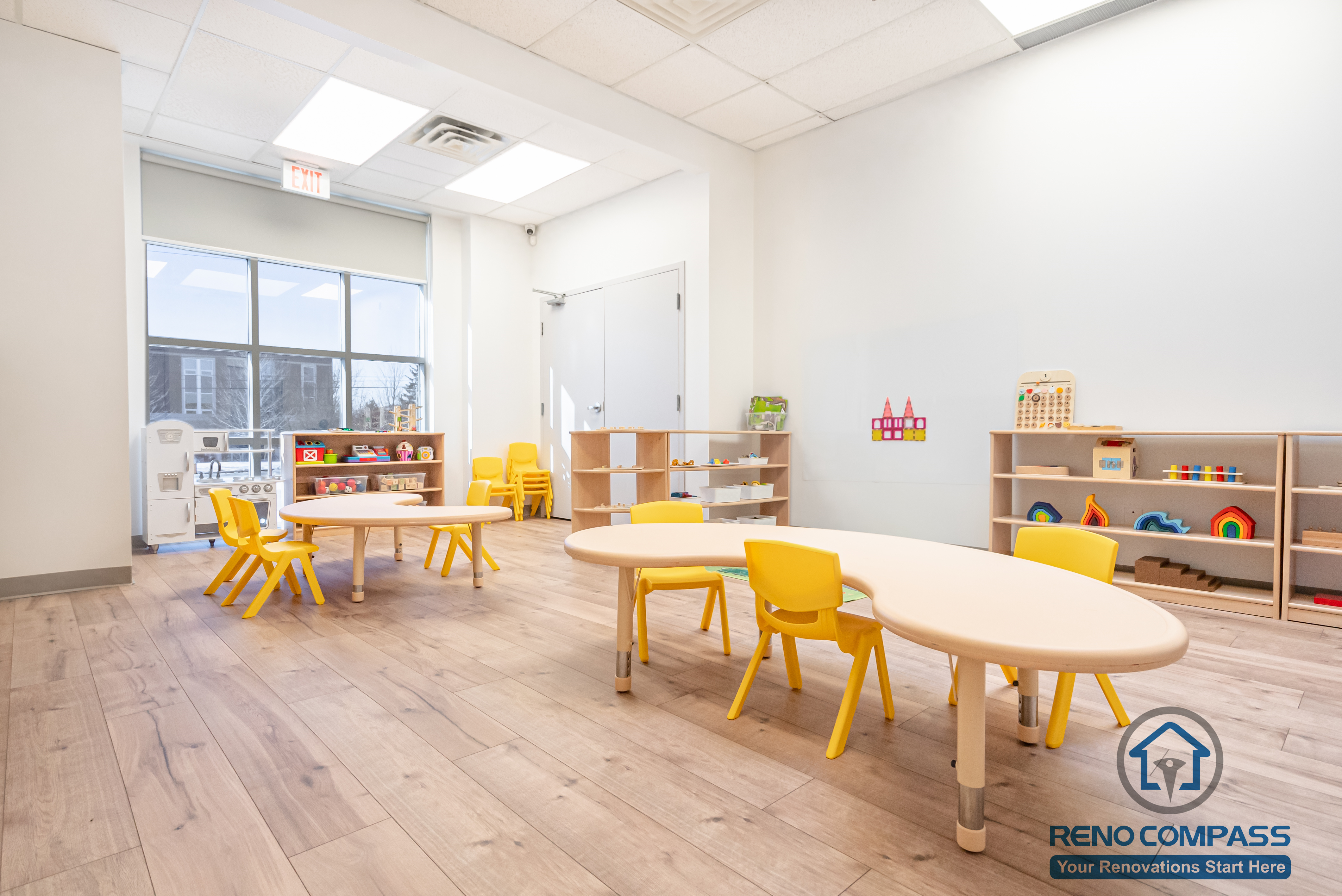 This Markham daycare renovation showcases a spacious classroom learning area designed to support group activities, early education, and daily routines. Child-sized tables and chairs are arranged to encourage collaboration while maintaining clear circulation for supervision. Open shelving and low-height cubbies provide organized storage that promotes independence and easy access for children. Durable, slip-resistant flooring and bright overhead lighting ensure safety, comfort, and long-term usability. Completed by a Toronto renovation company, Reno Compass Inc., this daycare interior renovation reflects a thoughtful balance of educational functionality, safety compliance, and efficient space planning for modern childcare environments.