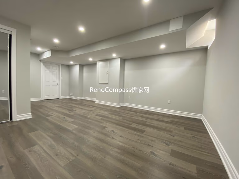 Spacious open-concept basement renovation in Richmond Hill featuring warm-toned laminate flooring, soft lighting, and sleek wall finishes. Reno Compass redesigned this area to maximize comfort and usability.