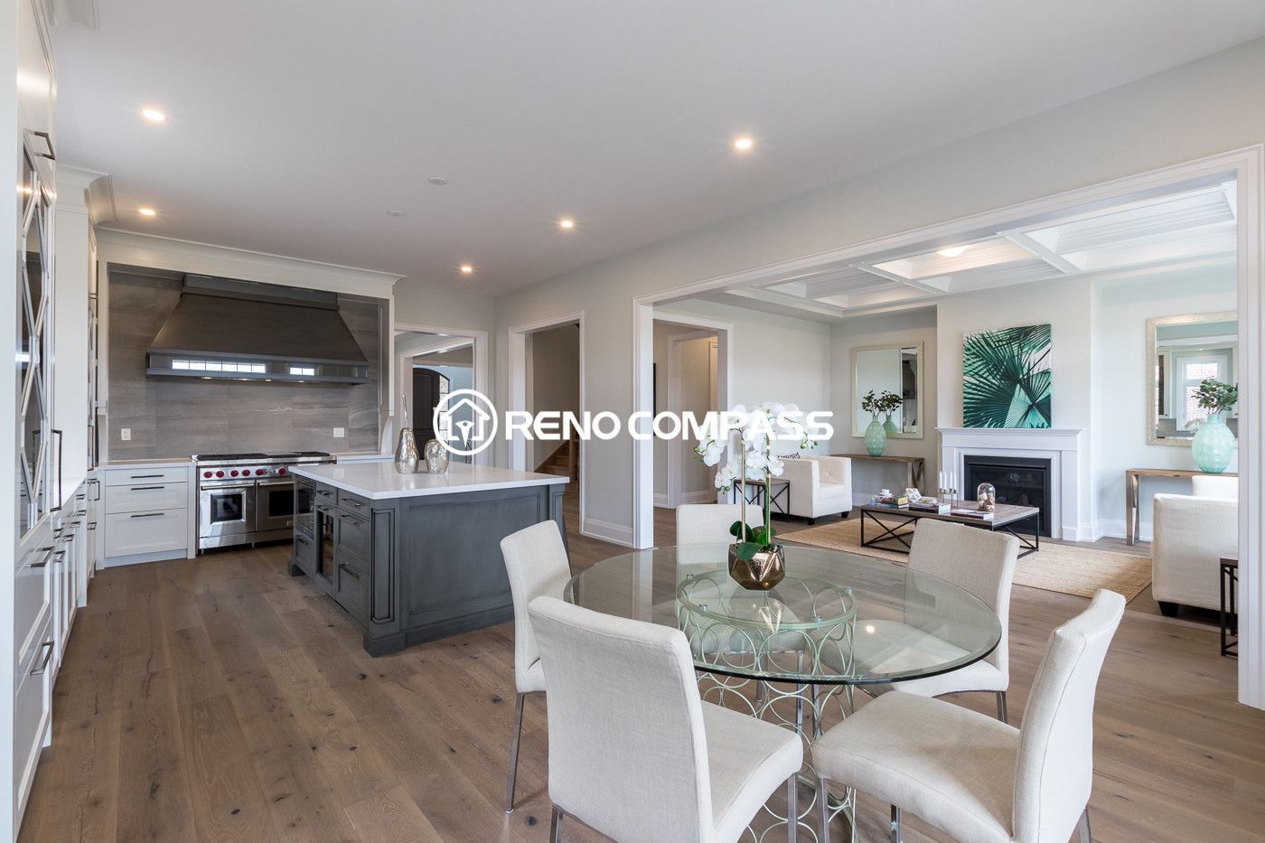 This Newmarket kitchen renovation showcases a spacious open-concept design with custom white cabinetry, a large quartz island, engineered wood flooring, and modern lighting. The kitchen flows seamlessly into the dining area, creating a bright and functional space for everyday living and entertaining. Completed by a trusted Toronto renovation company, Reno Compass Inc., the project highlights elegant design and high-quality craftsmanship.
