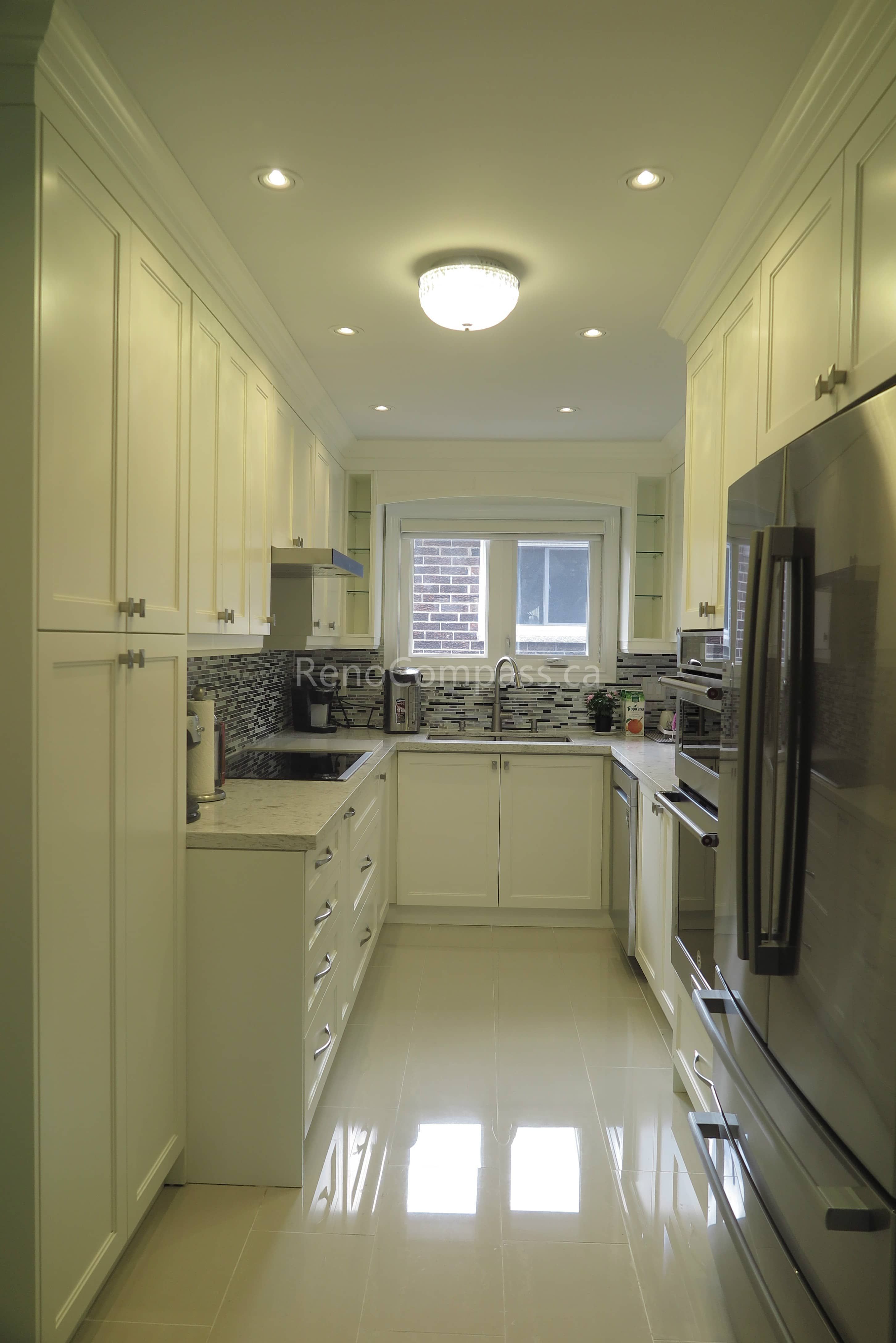 This Toronto interior renovation features a bright modern kitchen with custom white cabinetry, quartz countertops, built-in stainless steel appliances, and a stylish mosaic backsplash. The efficient layout maximizes storage and functionality while maintaining a clean, elegant look. Completed by a trusted Toronto renovation contractor, this project reflects Reno Compass Inc.’s expertise in delivering high-quality kitchen upgrades and refined interior finishes.