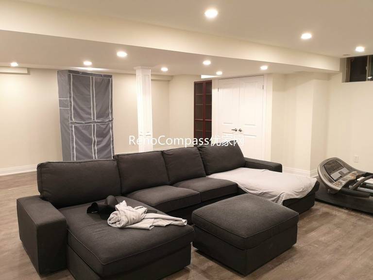 Spacious Richmond Hill basement entertainment area featuring open layout, sectional sofa lounge, upgraded flooring, and modern pot light ceiling design. Completed by Reno Compass Inc., this basement renovation creates a comfortable multi-purpose family and recreation space.
