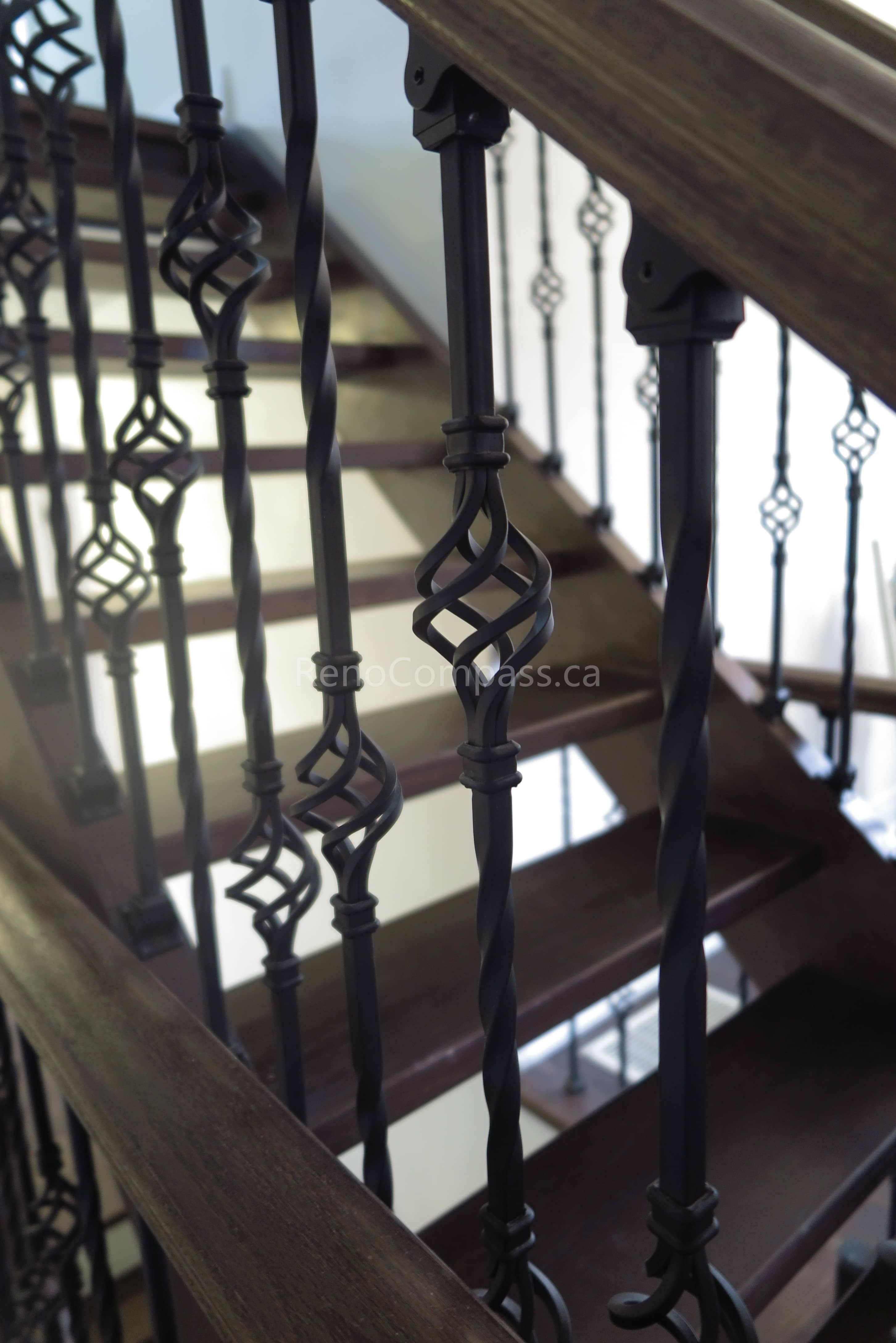 This Toronto interior renovation showcases a custom hardwood staircase paired with elegant wrought iron railings and decorative metal balusters. The combination of rich wood tones and detailed ironwork adds a timeless, upscale feel while improving safety and durability. Completed by a professional Toronto renovation contractor, this staircase renovation reflects Reno Compass Inc.’s craftsmanship and attention to detail in luxury interior finishing.