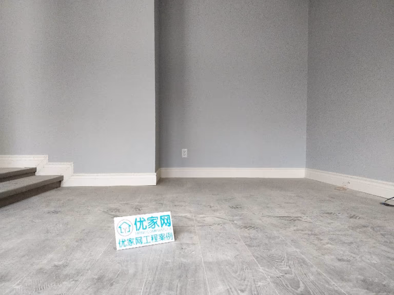Interior renovation project in Ajax showcasing new grey laminate flooring, freshly painted walls, and updated baseboards. The upgraded living space features a clean, modern finish and improved durability, completed by a professional Toronto renovation company focused on quality residential upgrades.