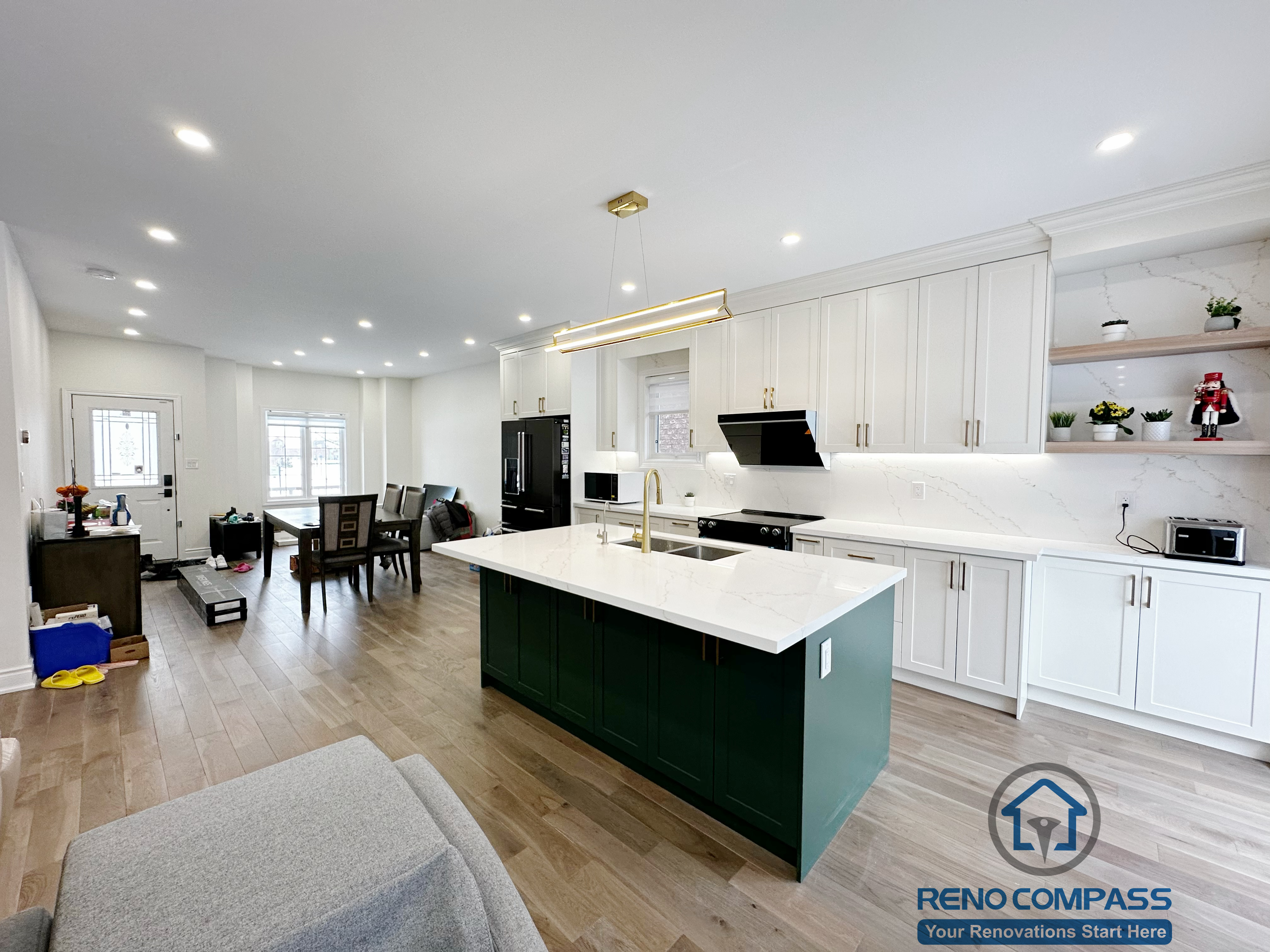 Interior renovation in Markham highlighting a spacious kitchen island with quartz countertop, integrated sink, and modern pendant lighting. The design enhances workflow, visual openness, and seamless connection between the kitchen and surrounding living areas.