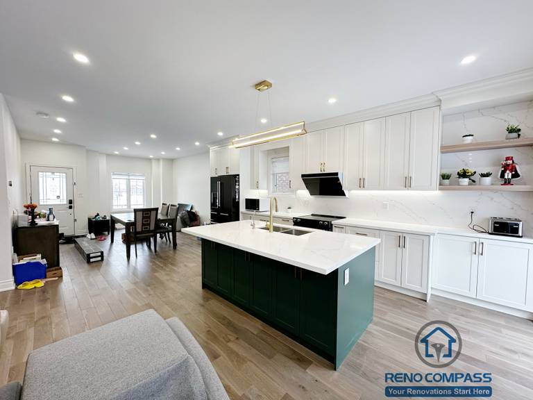 Interior renovation in Markham highlighting a spacious kitchen island with quartz countertop, integrated sink, and modern pendant lighting. The design enhances workflow, visual openness, and seamless connection between the kitchen and surrounding living areas.