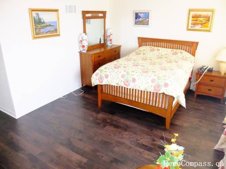 Toronto home hardwood flooring installation featuring deep-toned wood floors throughout the hallway and upper level. This professional flooring renovation enhances brightness, durability, and visual continuity, completed by Reno Compass for a clean and modern interior upgrade.