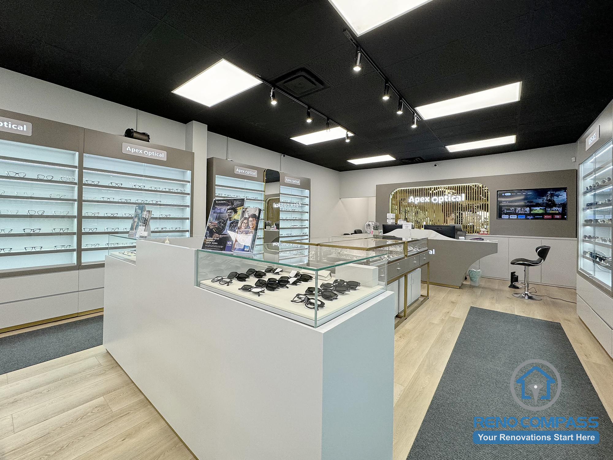 This Mississauga optical store interior renovation showcases an open retail layout with central eyewear display islands, wall-mounted shelving, and integrated lighting. The design improves customer flow, enhances product visibility, and creates a clean, modern commercial environment for optical retail.