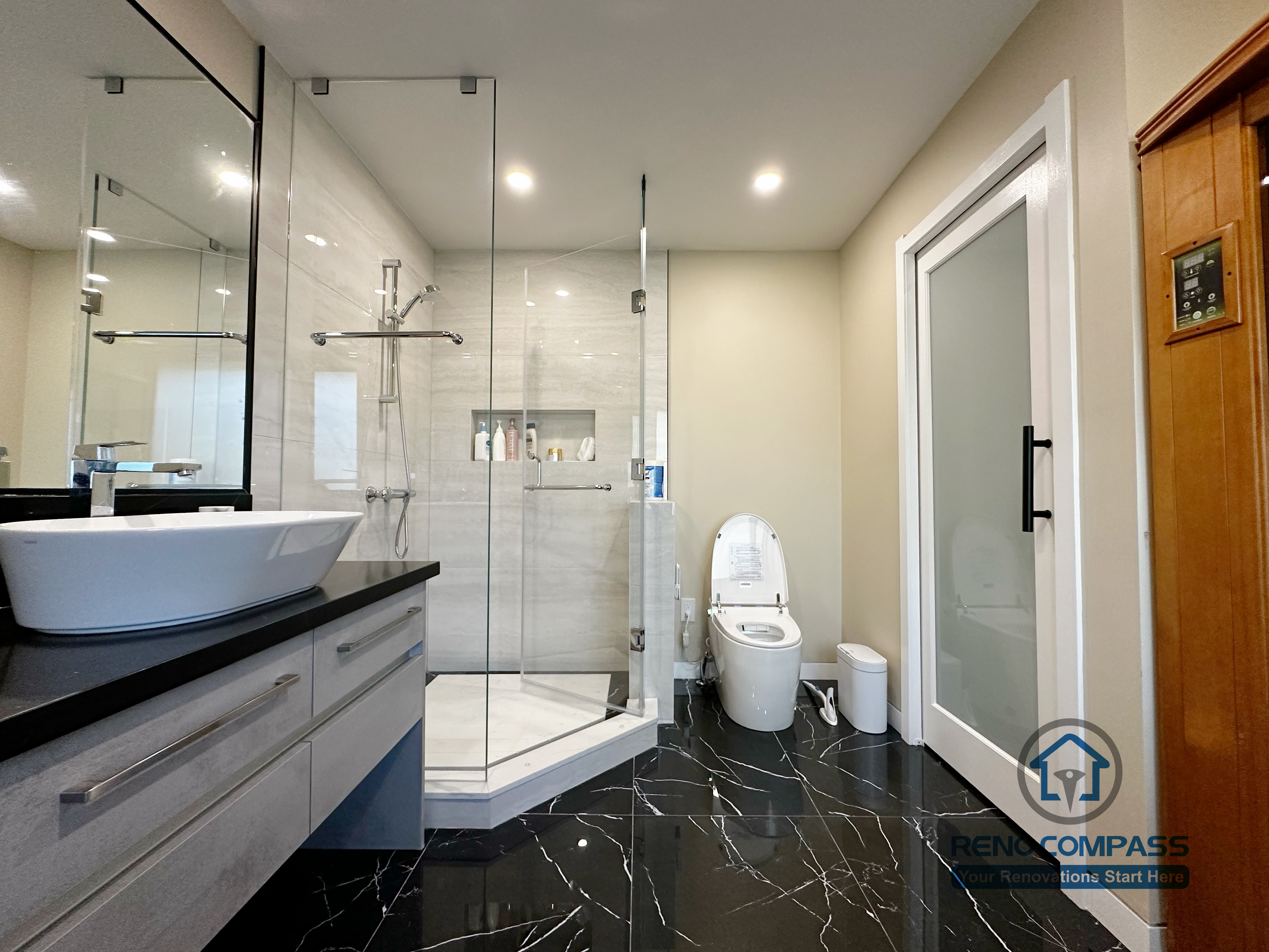 Modern bathroom completed as part of a North York interior renovation. This space features a frameless glass shower, large-format wall tiles, black marble-look flooring, and a custom vanity with vessel sink. Designed for durability, comfort, and clean visual balance by a professional Toronto renovation company.