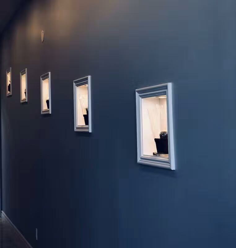 A stylish interior wall feature installed in a North York commercial renovation project. The dark accent wall is complemented by evenly spaced decorative framed display niches, creating a modern and artistic atmosphere for a restaurant or entertainment venue interior.