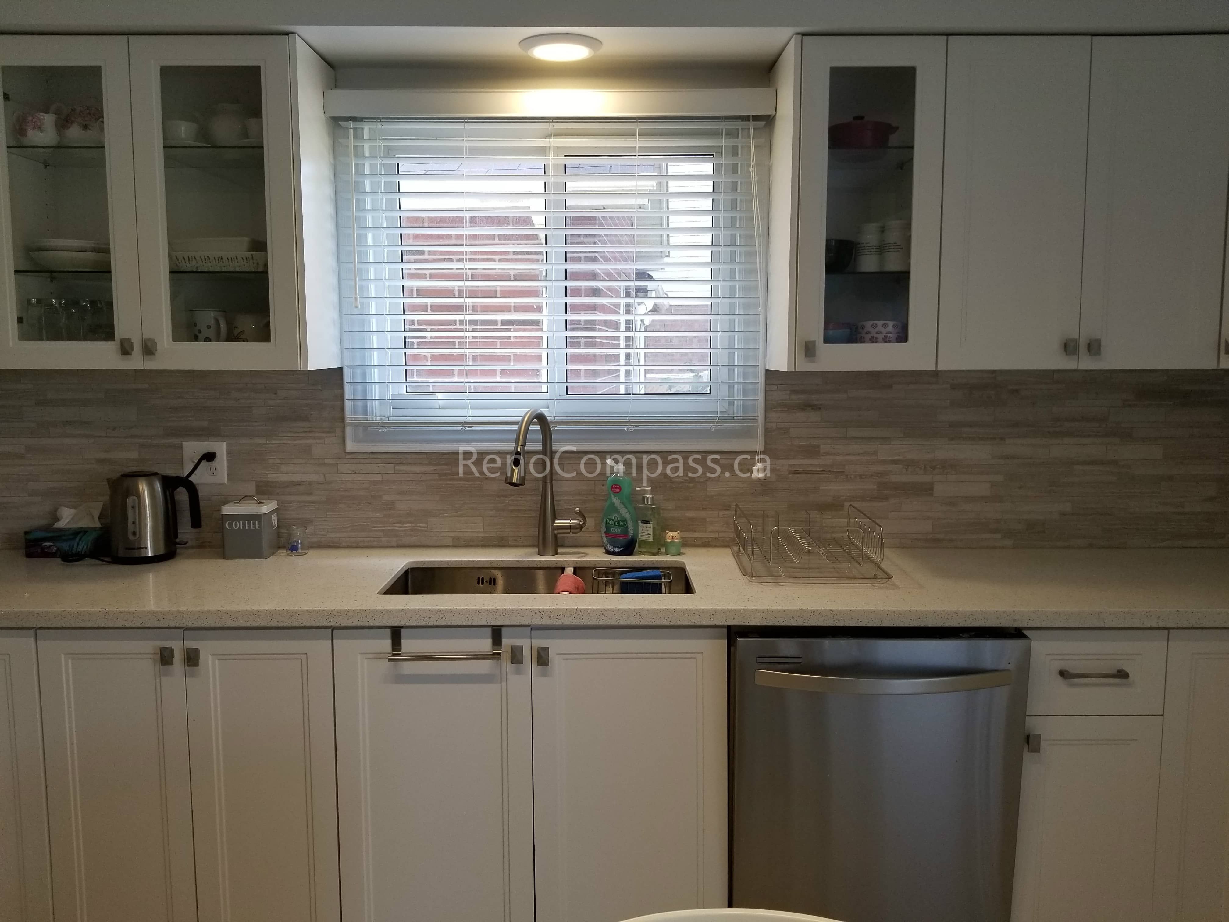 This Mississauga kitchen renovation features custom white cabinetry, a modern backsplash installation, and an upgraded sink and faucet setup. The clean layout, bright window lighting, and stainless steel appliances create a functional and welcoming cooking environment with a timeless contemporary style.

Completed by Reno Compass Inc., this kitchen upgrade highlights quality craftsmanship, practical storage solutions, and refined finishing details to enhance both daily living and property value.