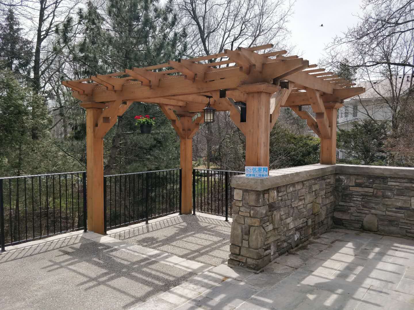 This Oakville landscaping project features a custom-built wooden pergola designed to enhance outdoor comfort and architectural appeal. The solid timber structure provides partial shade while maintaining openness and natural light. Integrated with stone base detailing and metal railing, the pergola creates a refined outdoor gathering space overlooking the backyard.
