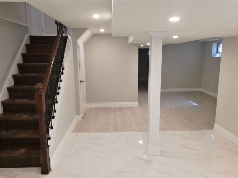 Scarborough whole-house interior renovation featuring a fully finished basement with upgraded staircase, modern flooring, and open-concept layout. This renovation highlights improved lighting, structural column detailing, and clean contemporary finishes designed to enhance comfort and functionality by a professional Toronto renovation contractor.