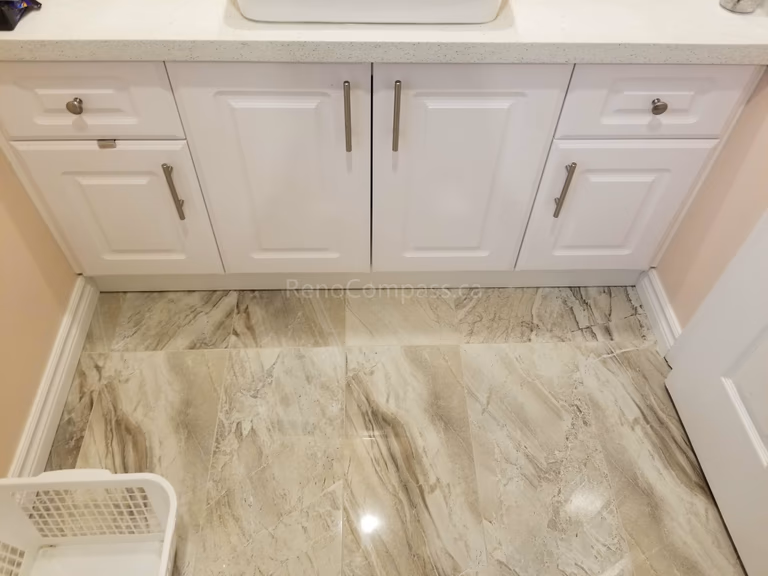 This Markham bathroom renovation includes a newly installed custom vanity with a modern countertop vessel sink and upgraded faucet. The clean white cabinetry provides ample storage while complementing the new floor tiles and overall bathroom design. The refreshed vanity area enhances both functionality and style, creating a bright, organized, and contemporary bathroom space for daily use.