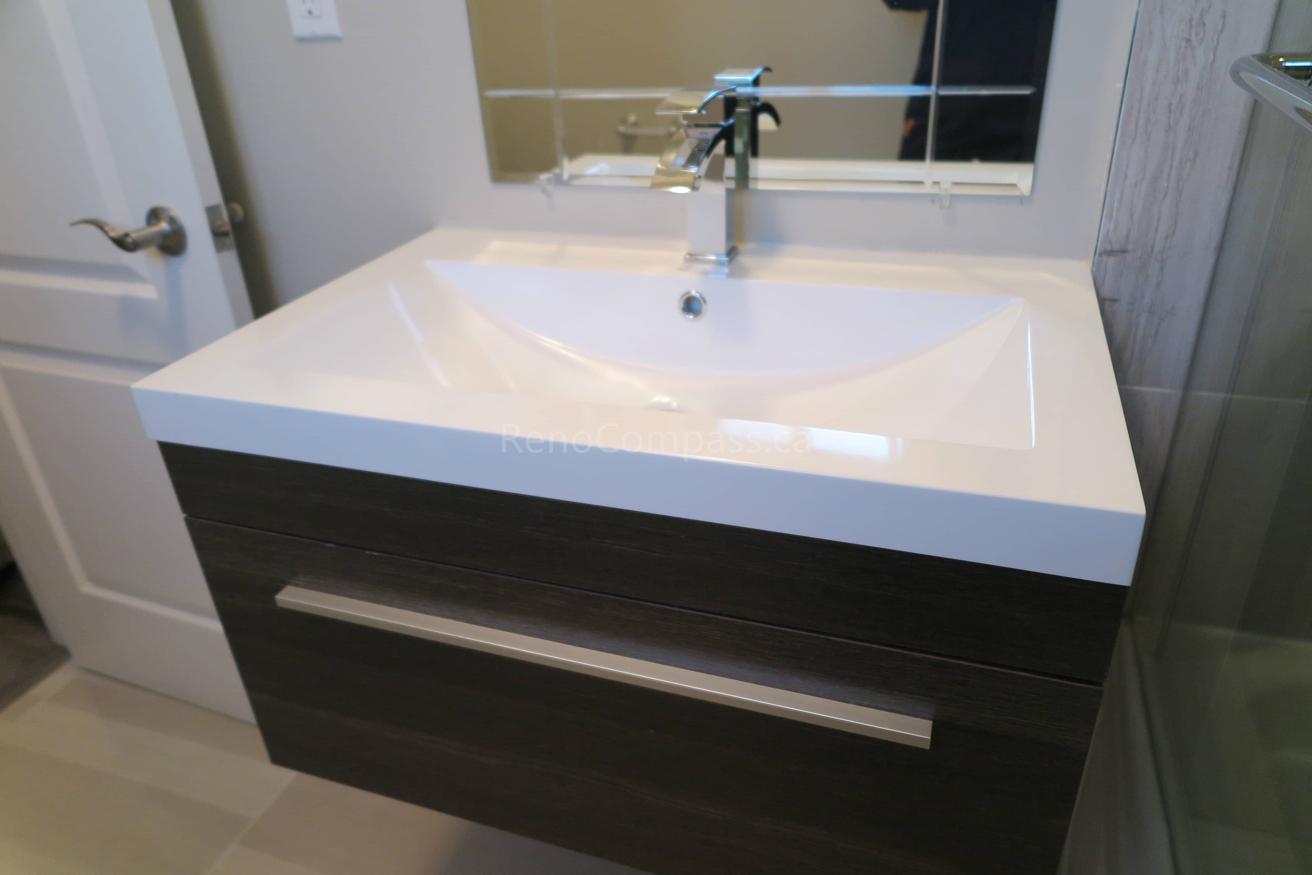 This Markham bathroom renovation features a sleek modern floating vanity with an integrated quartz sink and contemporary chrome faucet. Clean lines, durable materials, and minimalist design create a functional and stylish bathroom space that is easy to maintain. Completed by Reno Compass, a professional renovation contractor specializing in bathroom renovations, vanity installation, and full interior remodeling across Markham and the Greater Toronto Area.