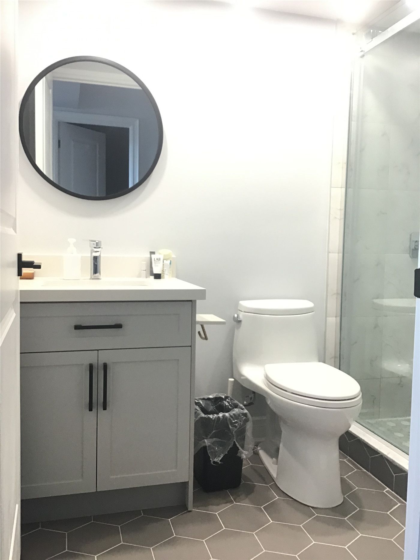 Modern bathroom vanity installation in a Richmond Hill condo renovation project. The upgrade features a clean white quartz countertop, integrated sink, contemporary faucet, and custom vanity cabinet with practical storage. This renovation enhances both functionality and visual appeal, creating a bright and minimalist bathroom space suitable for modern condo living.