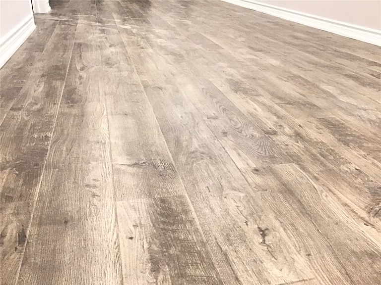 Aurora basement renovation featuring durable luxury vinyl plank flooring with natural wood-grain texture. The waterproof, scratch-resistant finish is ideal for basement spaces, offering both warmth and long-term performance. Installed by an experienced Toronto renovation company to ensure precise alignment, smooth transitions, and a seamless modern look.