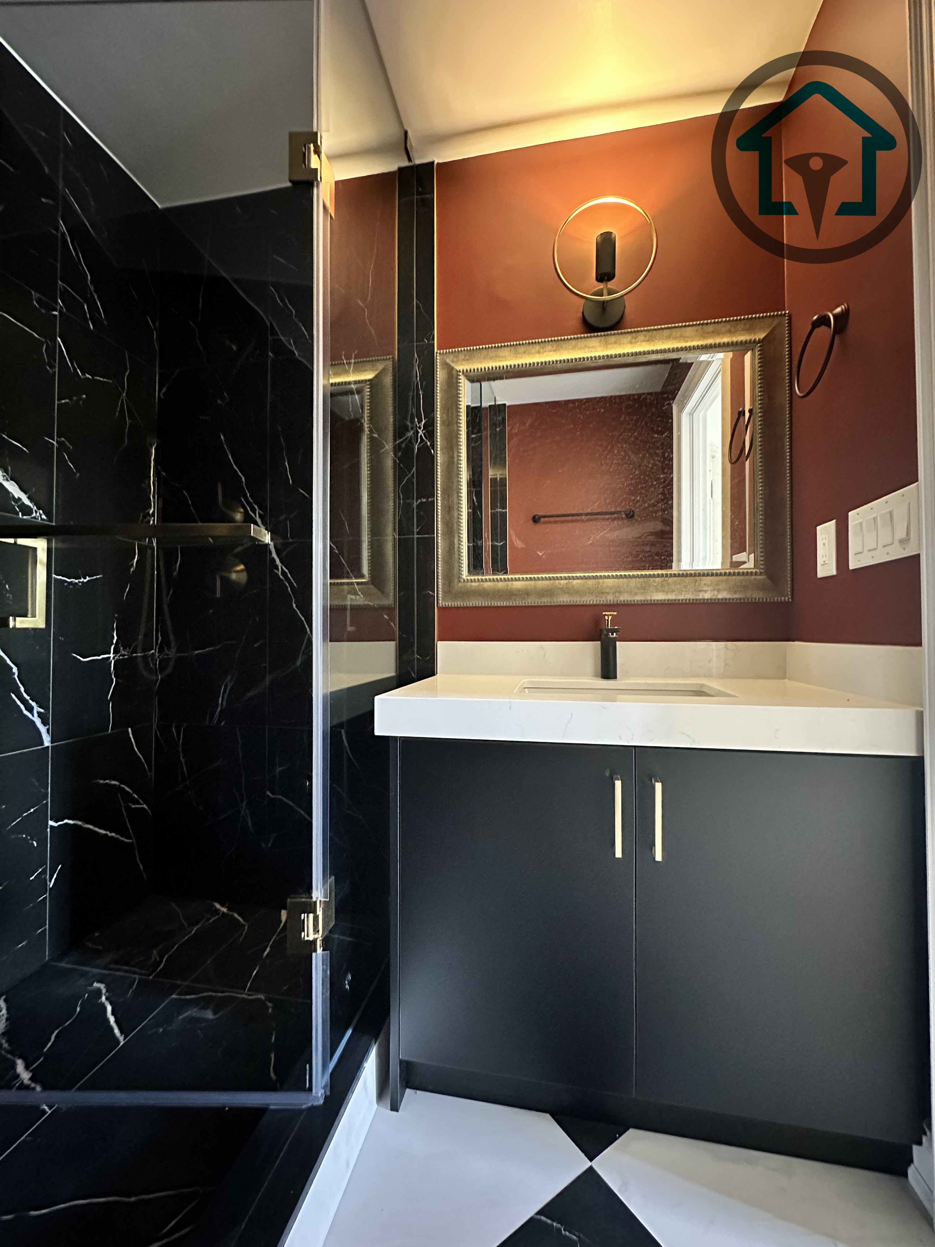 This powder room renovation showcases a dramatic black marble walk-in shower paired with a minimalist vanity and clean-lined fixtures. Frameless glass panels enhance openness while bold material contrast adds visual depth. Completed as part of a North York interior renovation, this space reflects the craftsmanship and design coordination of an experienced Toronto renovation company.