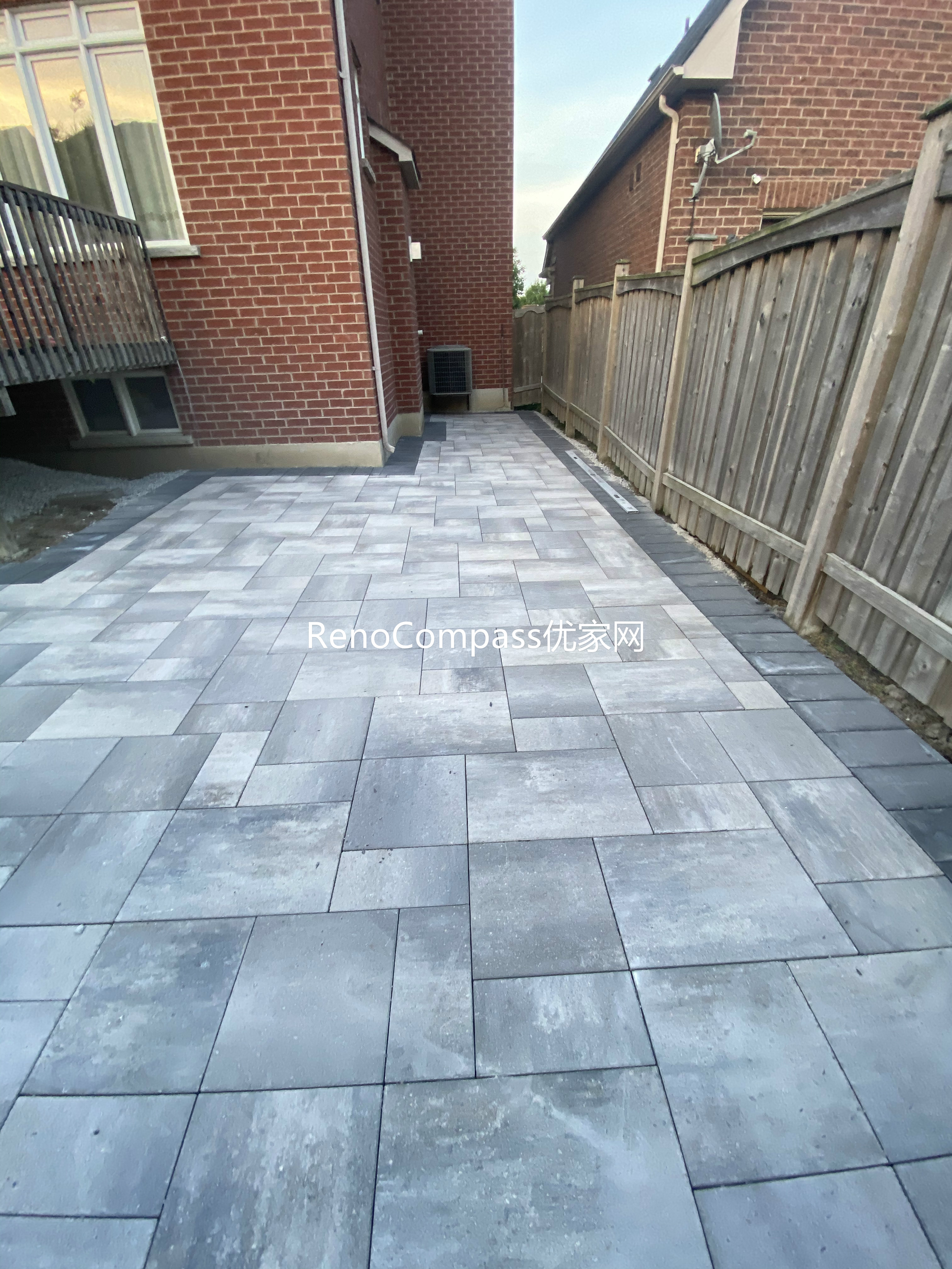 This Markham landscaping and interlocking project features a newly installed side yard walkway designed to improve accessibility and drainage along the property. Large-format interlocking stones were laid in a staggered pattern to create a stable, slip-resistant surface that connects the backyard patio to the front and side entrances. Precise alignment and proper base preparation ensure long-term durability and minimal maintenance. The neutral grey stone tones complement the brick exterior and fencing, creating a clean and cohesive outdoor transition. This interlocking walkway installation was completed by Reno Compass, serving homeowners in Markham and across the GTA.