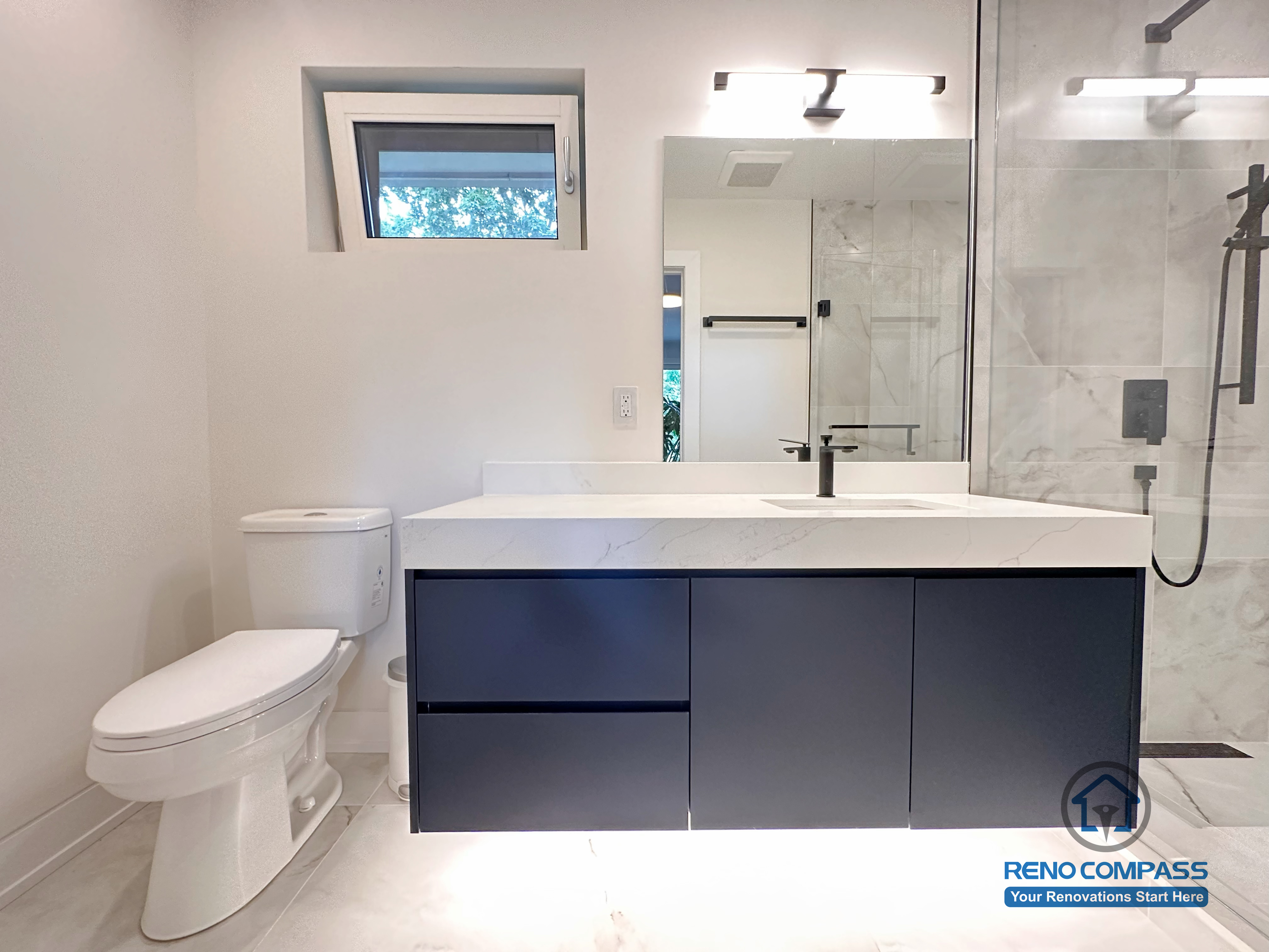 Modern bathroom renovation in Toronto showcasing a frameless glass walk-in shower, large-format marble-look tiles, floating custom vanity, and matte black fixtures. Completed by a professional Toronto renovation company with a focus on clean lines, durability, and contemporary design.