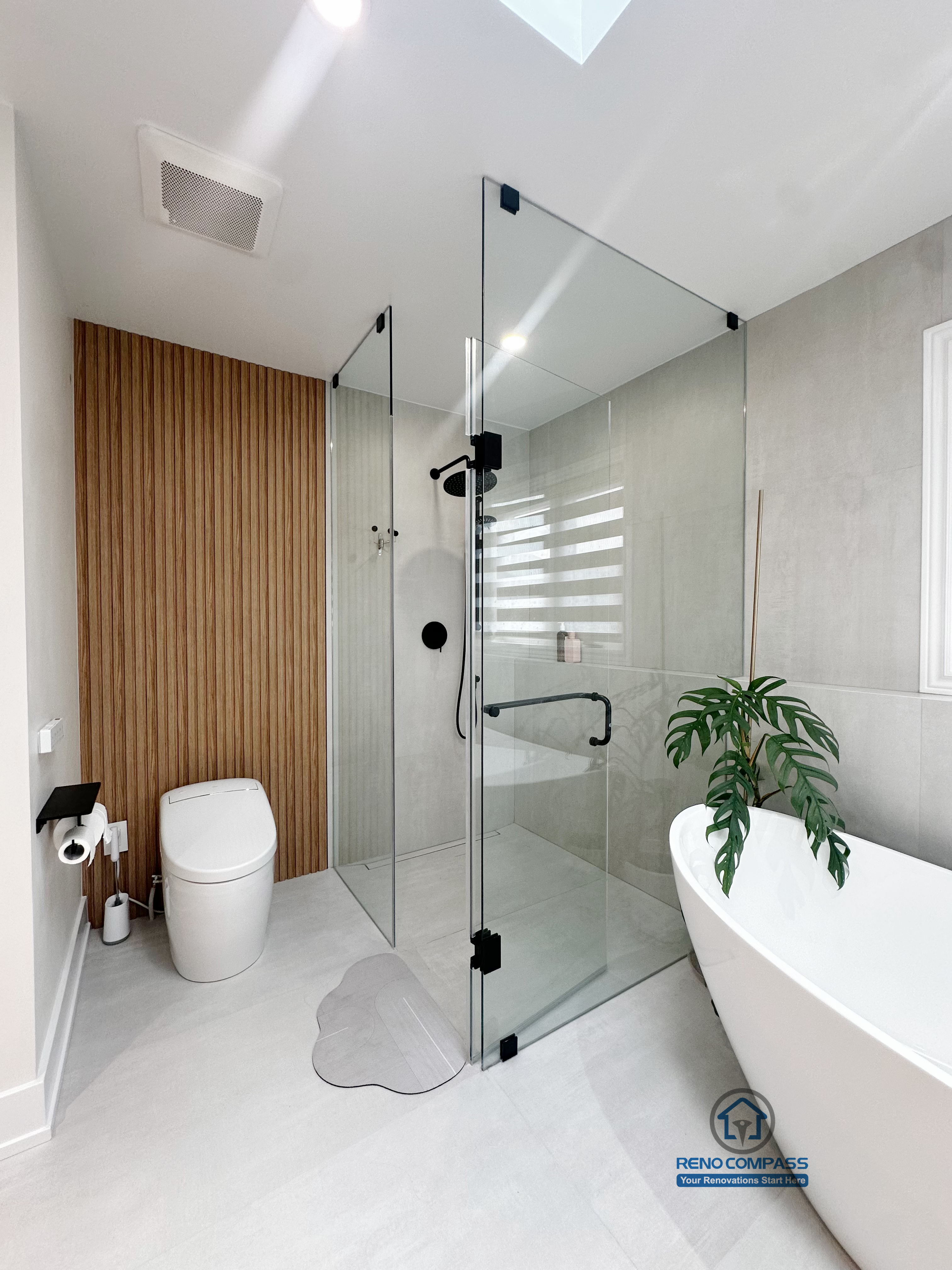 A modern curbless bathroom renovation by Reno Compass in Markham, Toronto.
This vertical view highlights a seamless glass shower enclosure, freestanding bathtub, and clean circulation that enhances accessibility, openness, and everyday usability.