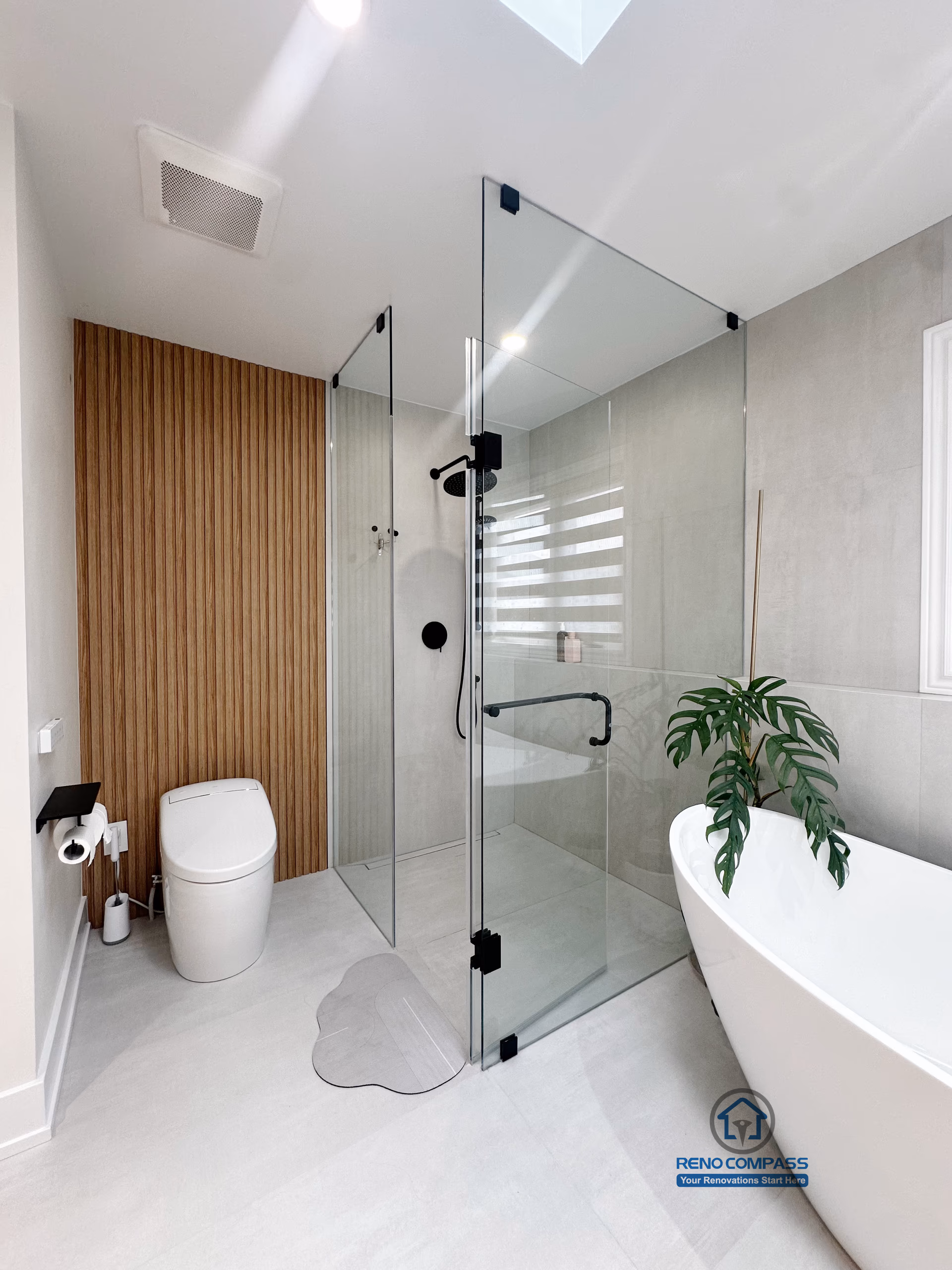 A modern curbless bathroom renovation by Reno Compass in Markham, Toronto.
This vertical view highlights a seamless glass shower enclosure, freestanding bathtub, and clean circulation that enhances accessibility, openness, and everyday usability.