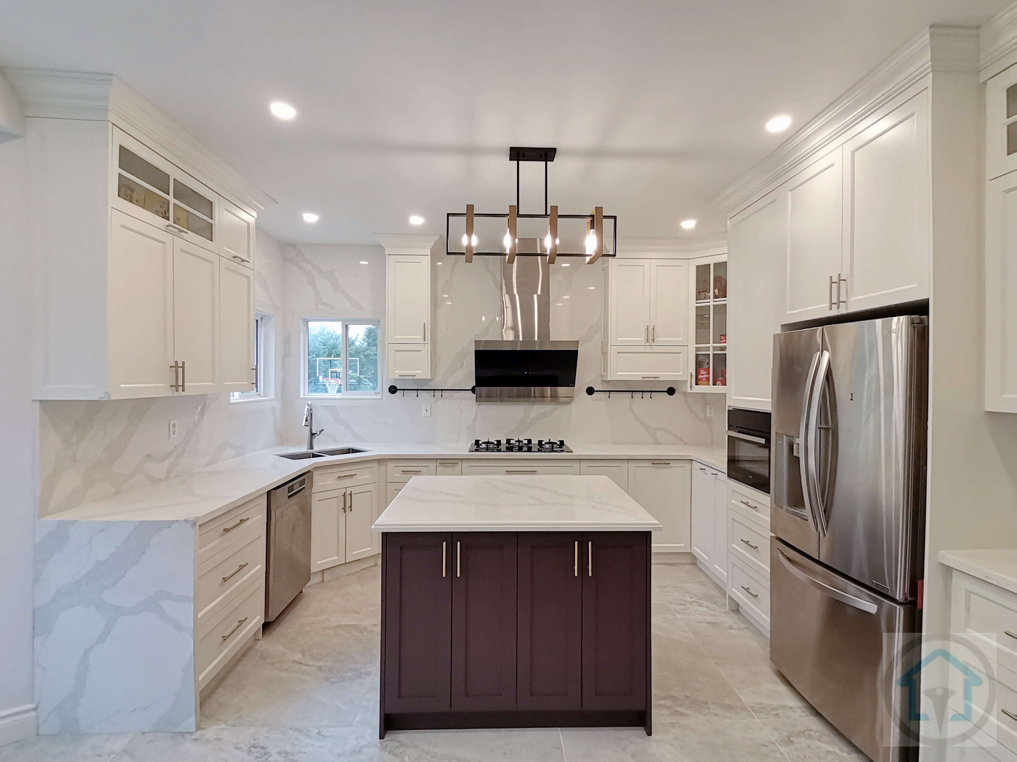 This bright white kitchen renovation showcases a clean, symmetrical layout centered around a statement dark-toned island. Full-height custom cabinetry, marble-look backsplash, and large-format floor tiles create a cohesive and upscale visual flow while enhancing light reflection throughout the space. The central island anchors the kitchen with added storage and prep space, making it ideal for both daily use and entertaining. Stainless steel appliances, integrated lighting, and a modern range hood complete the design with a balance of functionality and elegance. Completed by an experienced Toronto renovation company, this kitchen renovation highlights thoughtful planning, refined material selection, and long-term livability for modern family homes.