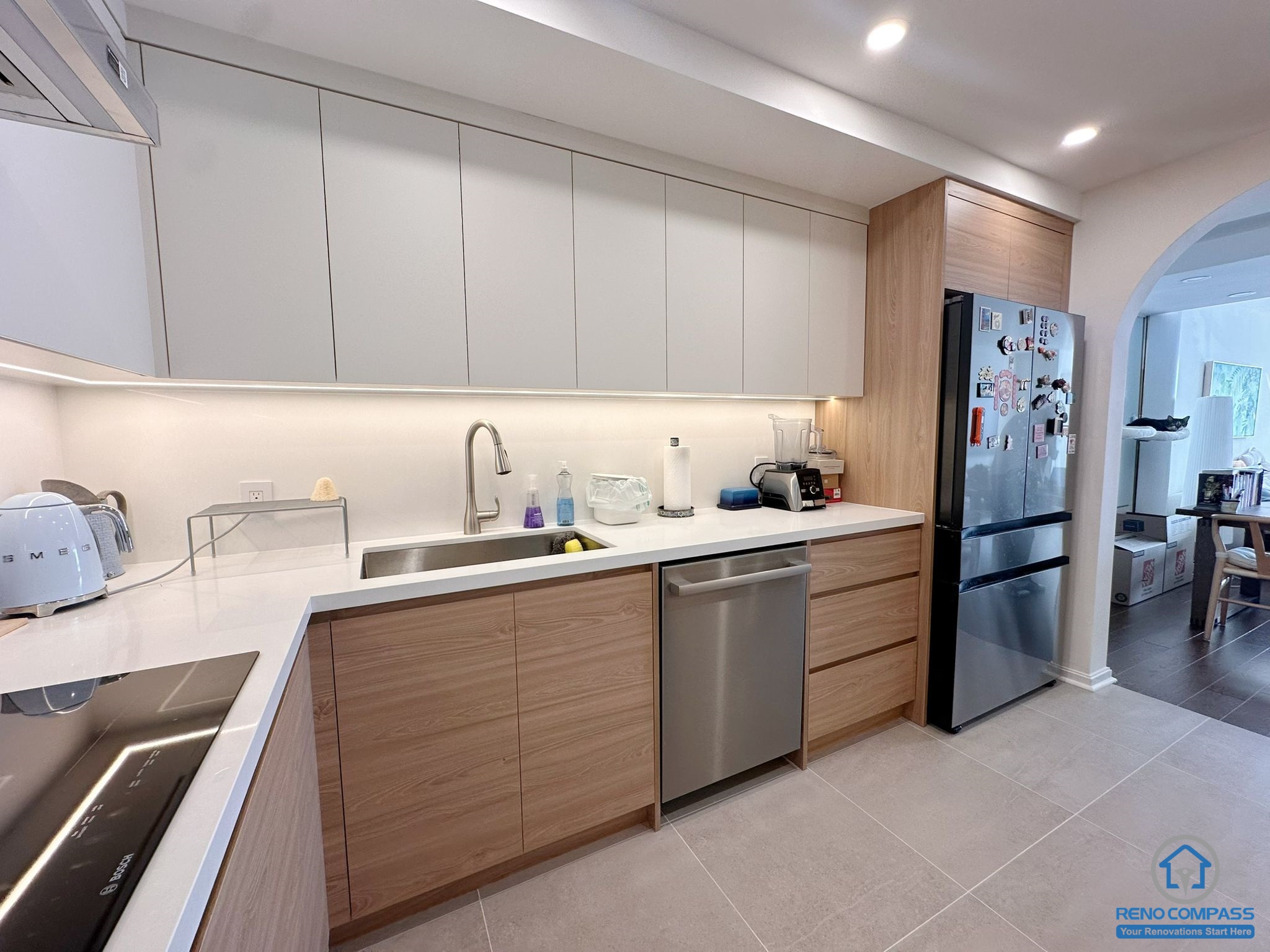 A fully renovated modern kitchen in Toronto featuring custom wood cabinetry, integrated appliances, recessed lighting, and a clean contemporary layout. The new design maximizes storage, workflow, and modern aesthetics for everyday living.