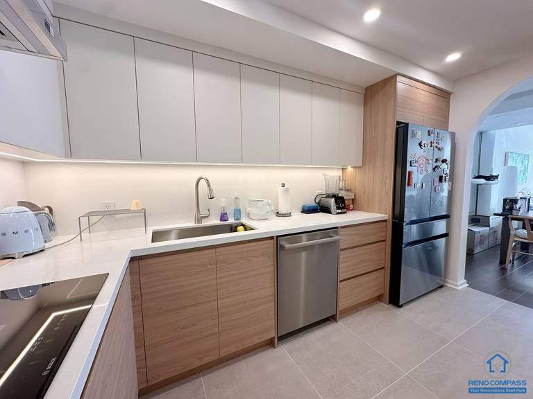 A fully renovated modern kitchen in Toronto featuring custom wood cabinetry, integrated appliances, recessed lighting, and a clean contemporary layout. The new design maximizes storage, workflow, and modern aesthetics for everyday living.