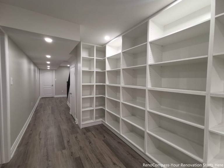 This Oakville basement renovation features custom built-in storage shelving designed to maximize organization and functionality in a modern finished basement. The upgraded space includes new flooring, smooth ceilings, recessed pot lights, and a clean hallway layout that enhances brightness and usability. Completed by a trusted Toronto renovation company, this basement renovation focuses on practical storage solutions, durable materials, and contemporary design, creating a versatile lower-level living space that adds long-term value to the home.