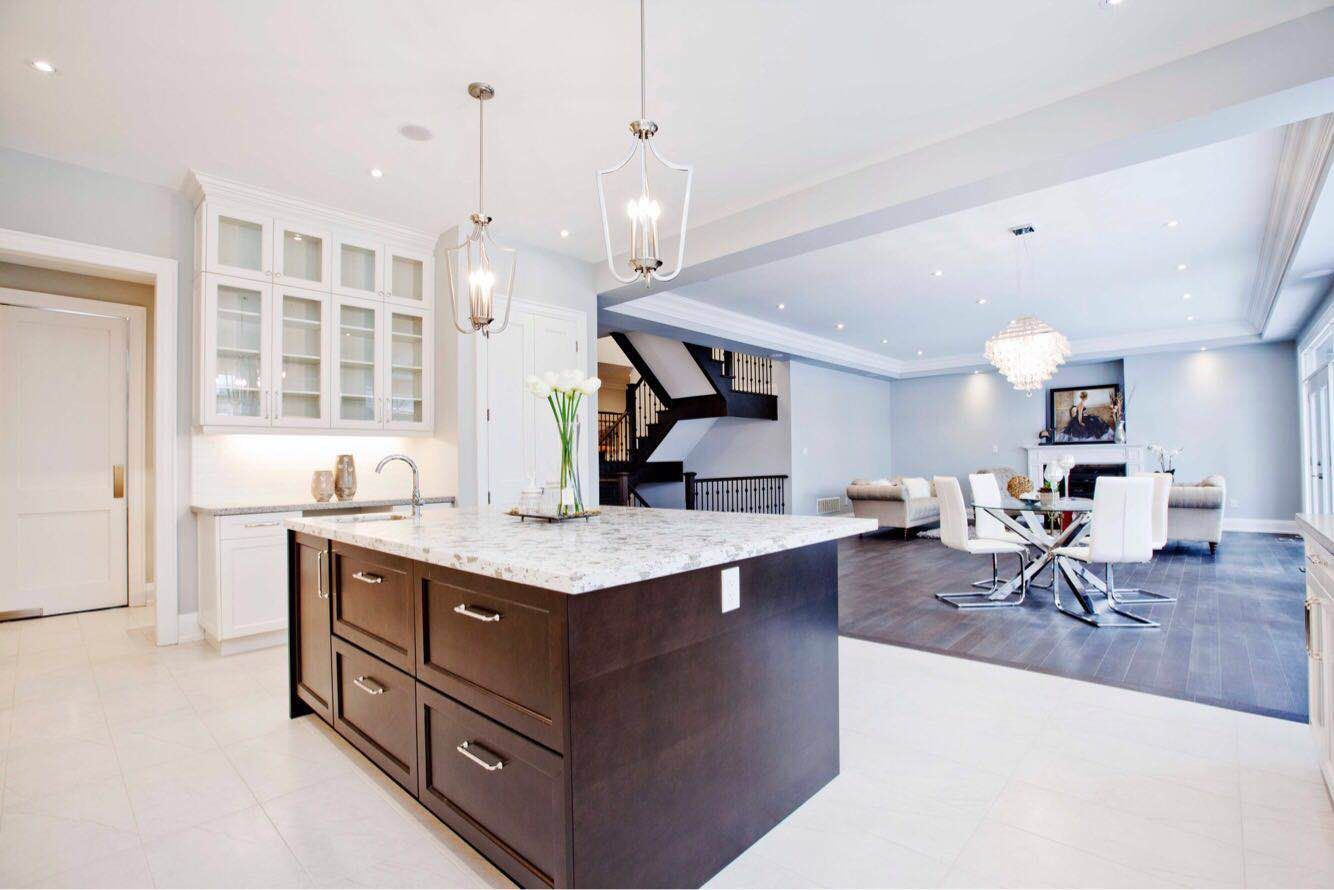 Modern luxury kitchen completed as part of a Toronto design build custom build project, featuring a large central island, custom white cabinetry, quartz countertops, and premium stainless steel appliances. This whole house renovation Toronto project highlights the clean design, spacious layout, and high-end finishes that define luxury custom kitchens in Toronto homes.