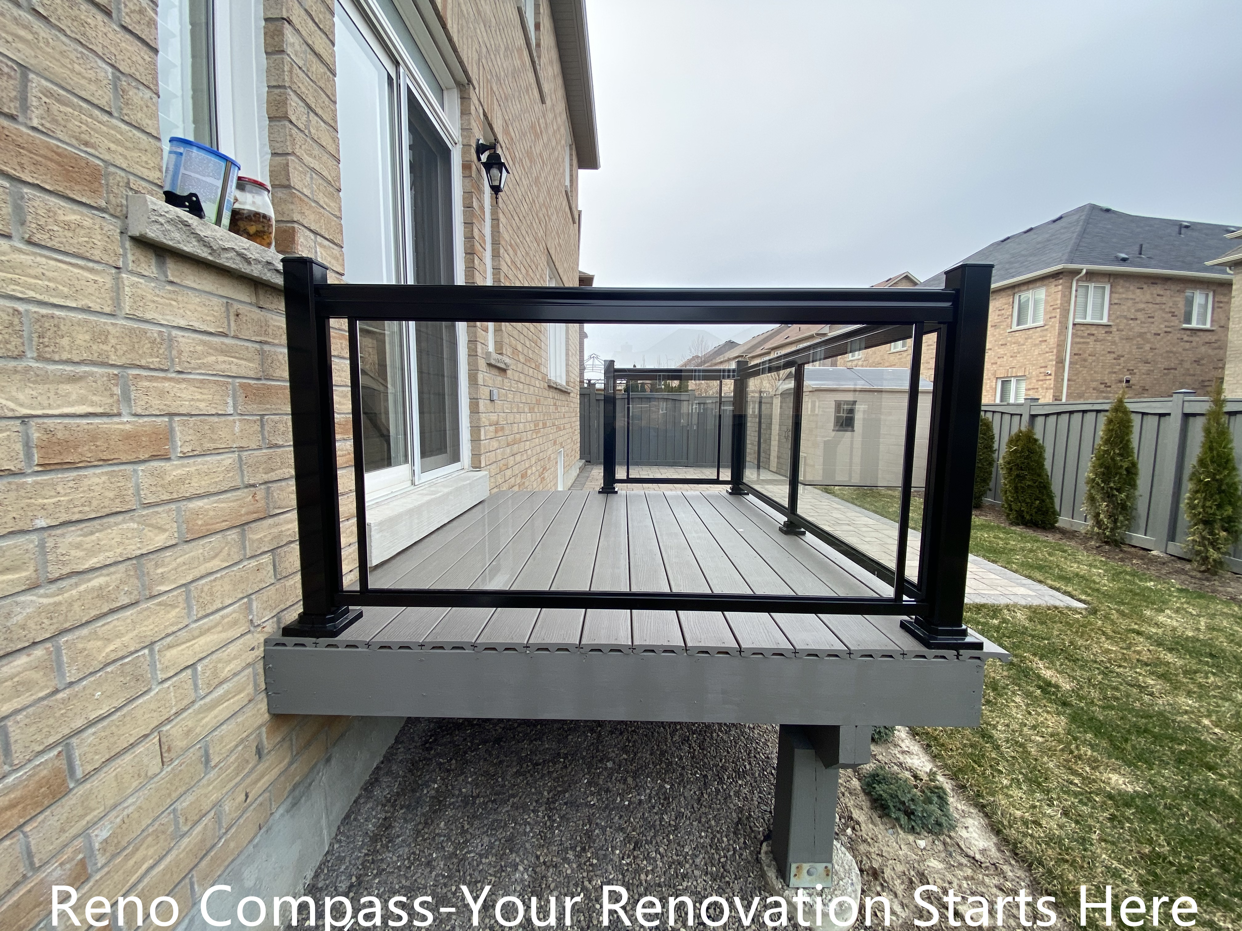 Composite backyard deck renovation in Newmarket featuring durable deck boards and black aluminum railing with clean, modern lines. The raised deck structure provides a safe and functional outdoor platform while enhancing the connection between indoor living space and the backyard. Built by a professional Toronto renovation company with a focus on structural stability and long-term performance.