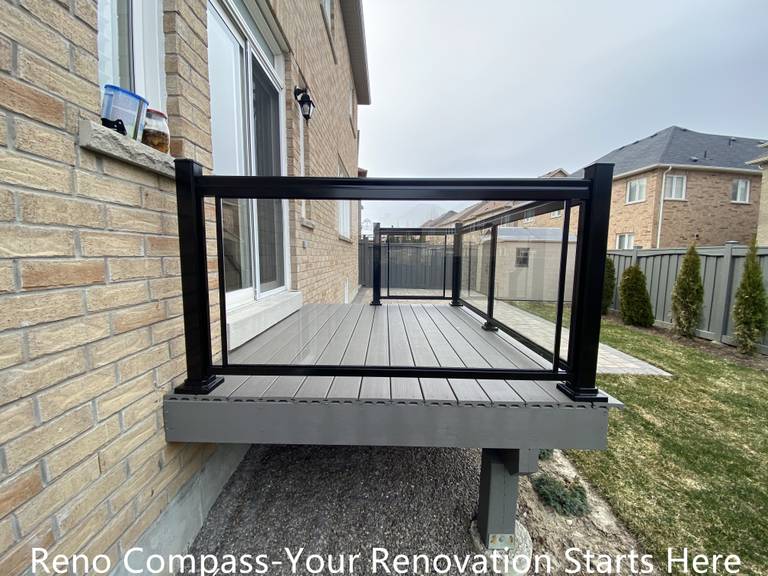 Composite backyard deck renovation in Newmarket featuring durable deck boards and black aluminum railing with clean, modern lines. The raised deck structure provides a safe and functional outdoor platform while enhancing the connection between indoor living space and the backyard. Built by a professional Toronto renovation company with a focus on structural stability and long-term performance.