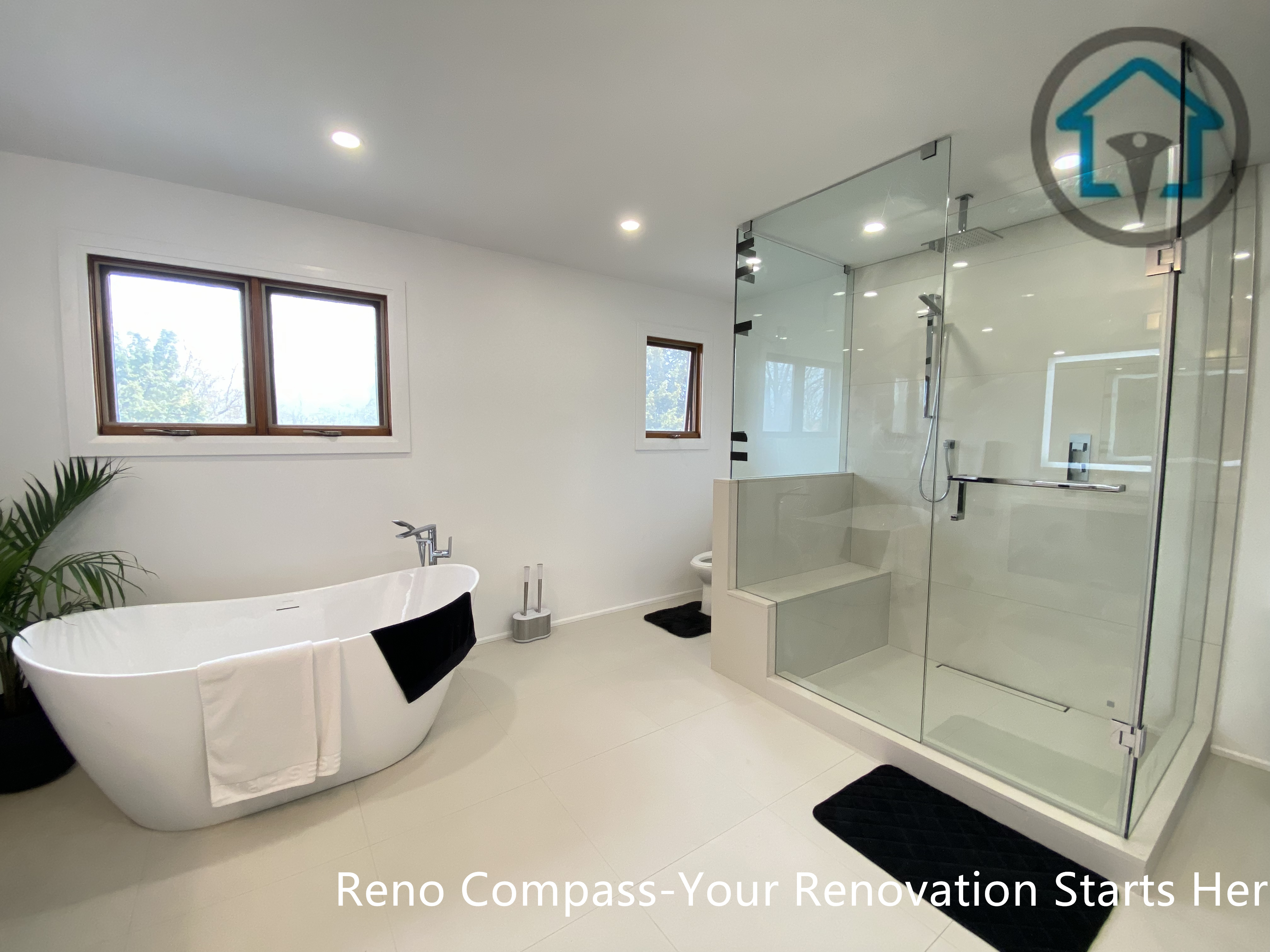 Modern bathroom renovation in Brampton featuring a freestanding soaking tub paired with a curbless glass walk-in shower. The open layout, neutral-tone flooring, and recessed ceiling lighting create a bright and spa-inspired atmosphere. Completed by a professional Toronto renovation company, this design balances luxury, accessibility, and long-term comfort for everyday living.