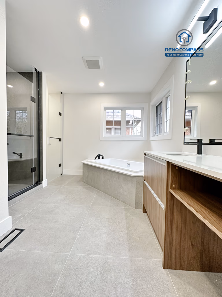 Full bathroom renovation in Richmond Hill showcasing a spacious and open layout with a modern soaking tub, large-format floor tiles, custom vanity cabinetry, and clean architectural lines for a bright and relaxing bathroom space.