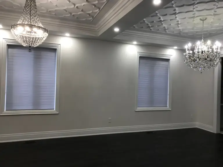 Custom zebra blinds installation in Toronto dining room by professional Toronto renovation company Reno Compass Inc. Featuring dual-layer light filtering shades, clean white window trim, modern chandelier lighting, and elegant wall panel detailing. This window treatment upgrade enhances privacy, natural light control, and interior aesthetics with a sleek and contemporary finish.